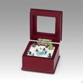 Sog. Spieluhr "Mini-Schlittschuhszene", im Wesentlichen bestehend aus einem Etui aus Holz (Antragstellerangabe) in Form einer quadratische Kiste mit einem Deckel mit Glassichtfenster und mit einem eingebauten und von außen per Hand aufzuziehenden Spieldosenmechanismus. Beim Aufklappen des Behältnisses wird eine winterliche Landschaft mit verschneiten Bäumen sowie verschiedenen Figuren sichtbar und die innere Szene mit Schlittschuhläufern auf einer Eisfläche dreht sich nach Aufziehen der Spieluhr zur Melodie "We wish you a Merry Christmas". 
Bei der Ware handelt es sich nicht um einen Weihnachtsartikel der Position 9505 des ZT, da die vorrangige Funktion das Spielen von Musik ist.

Die Ware ist als "Spieldose" einzureihen.

Anlage: 1 Abbildung