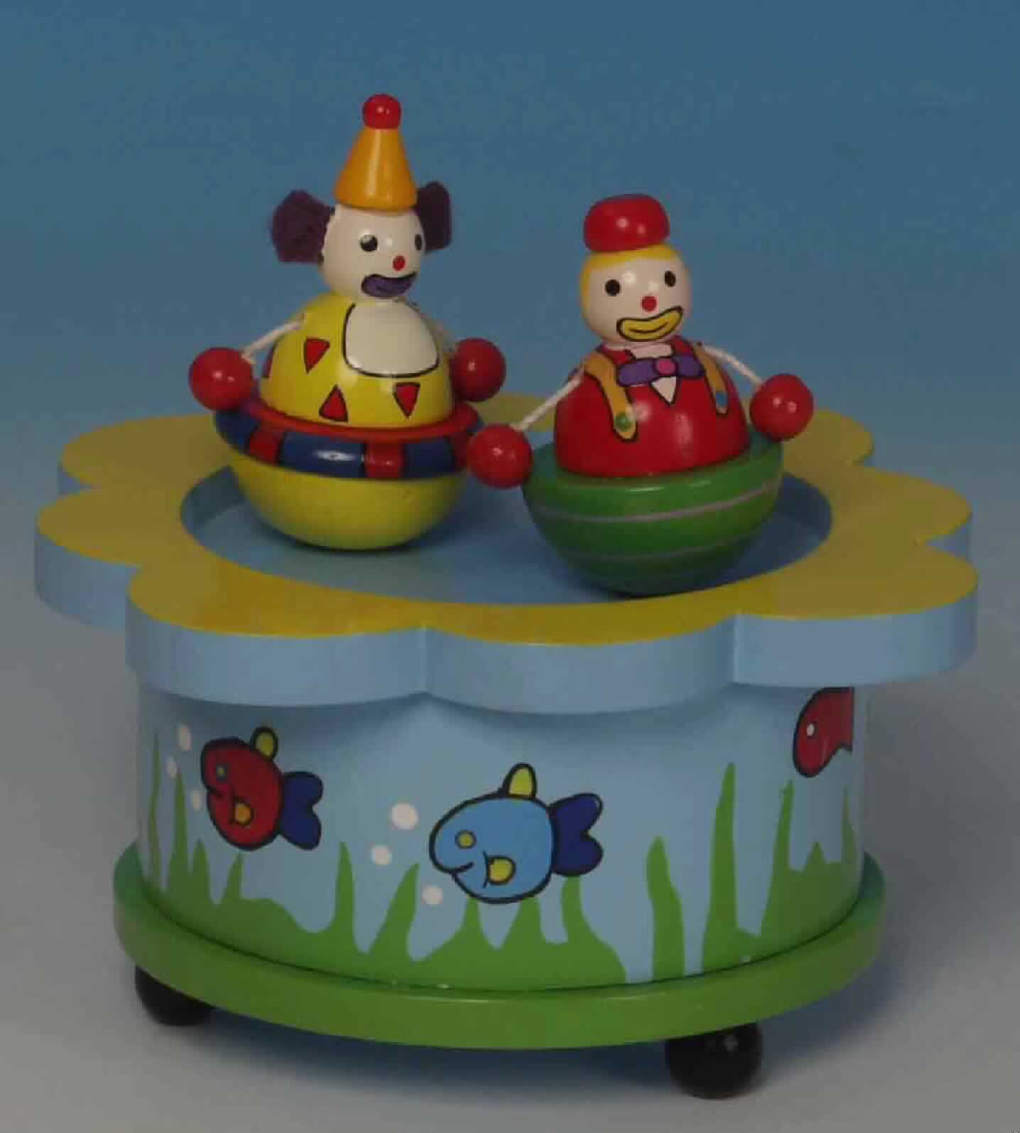 Sog. Spieluhr "Tanzclowns", im Wesentlichen bestehend aus einem bemalten und lackierten rechteckigen Kästchen aus Holz (ca. 10 x 10 x 5,5 cm groß) mit vier kugelförmigen Standfüßen, einem innen liegenden drehbaren Magneten, zwei lose auf das Kästchen aufgestellte, magnetische, ca. 5,5 cm große Holzfiguren (Clowns darstellend) und einem eingebauten mechanischen Spieldosenmechanismus. 
Wird der Spieldosenmechanismus an der Unterseite des Holzkästchens aufgezogen, ertönt die Melodie "Send in the clowns" und die Holzfiguren drehen sich auf dem Kästchen.

Die in einem Pappkarton mit Sichtfenster verpackte Ware ist als "Spieldose" einzureihen.

Anlage: 1 Abbildung