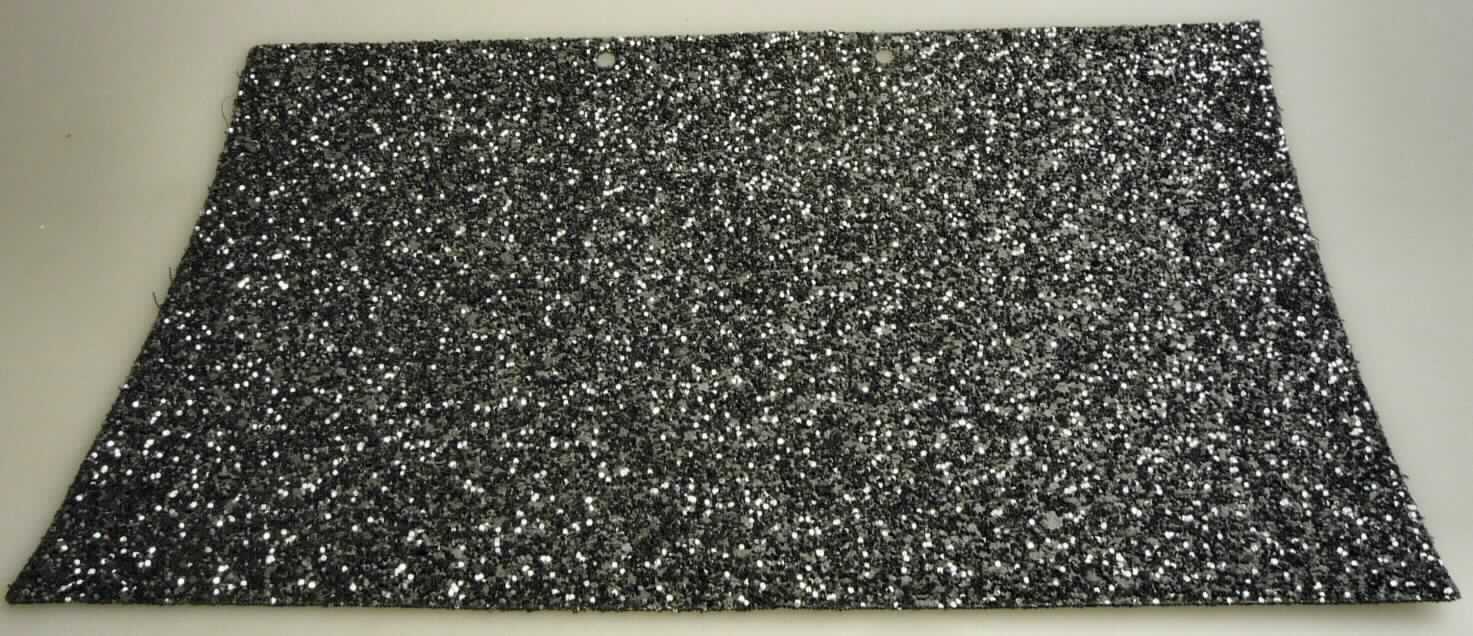 Gewebe, sog. Glitzer-Stoff, Foto siehe Anlage,
- als Meterware; laut Antrag mit einer Breite von 1,37 cm,
- laut Untersuchungsergebnis:
-- gefärbtes Gewebe aus laut Antrag Polyester und Baumwolle,
--- auf der Schauseite auf der ganzen Oberfläche mit klarsichtigem Kleber bestrichen und mit
    einer dünnen Lage aus metallisierten Kunststoff-Partikeln (keine Kügelchen) überdeckt.

"Überzogenes Gewebe, anderes als in den Positionen 5901 bis 5906 genannte,
 ohne in Klebstoff eingebettete Kügelchen"