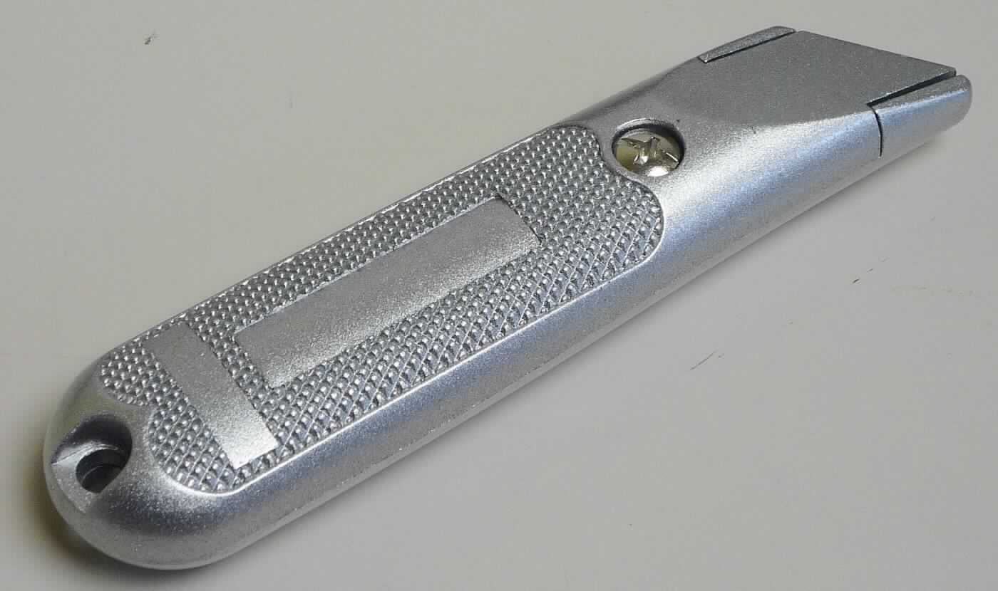 "Teppichmesser";
noch nicht zusammengesetztes Messer, bestehend aus

- einem zweiteiligen, ca. 13,5 cm langen, silberfarbenen Griff aus Zink-Druckguss,
  der mittels einer Schraube aus unedlem Metall zusammengehalten wird; erkennbar
  speziell zur Aufnahme einer auswechselbaren Trapezklinge bestimmt

- einer im Griff untergebrachten ca. 6 x 2 cm großen Trapezklinge aus unedlem Metall,
  mit beidseitig geschliffener, gerader, schneidender Klinge

- die Klinge wird am vorderen Ende des Griffes eingelegt und durch das Verschrauben der
  Griffhälften in einer festen Position fixiert

Abbildung siehe Anlage.

Derartige Erzeugnisse gehören als "andere Messer mit schneidender, feststehender Klinge aus unedlem Metall, kein Messer der Position 8208" zum TARIC-Code 8211 9200 00.