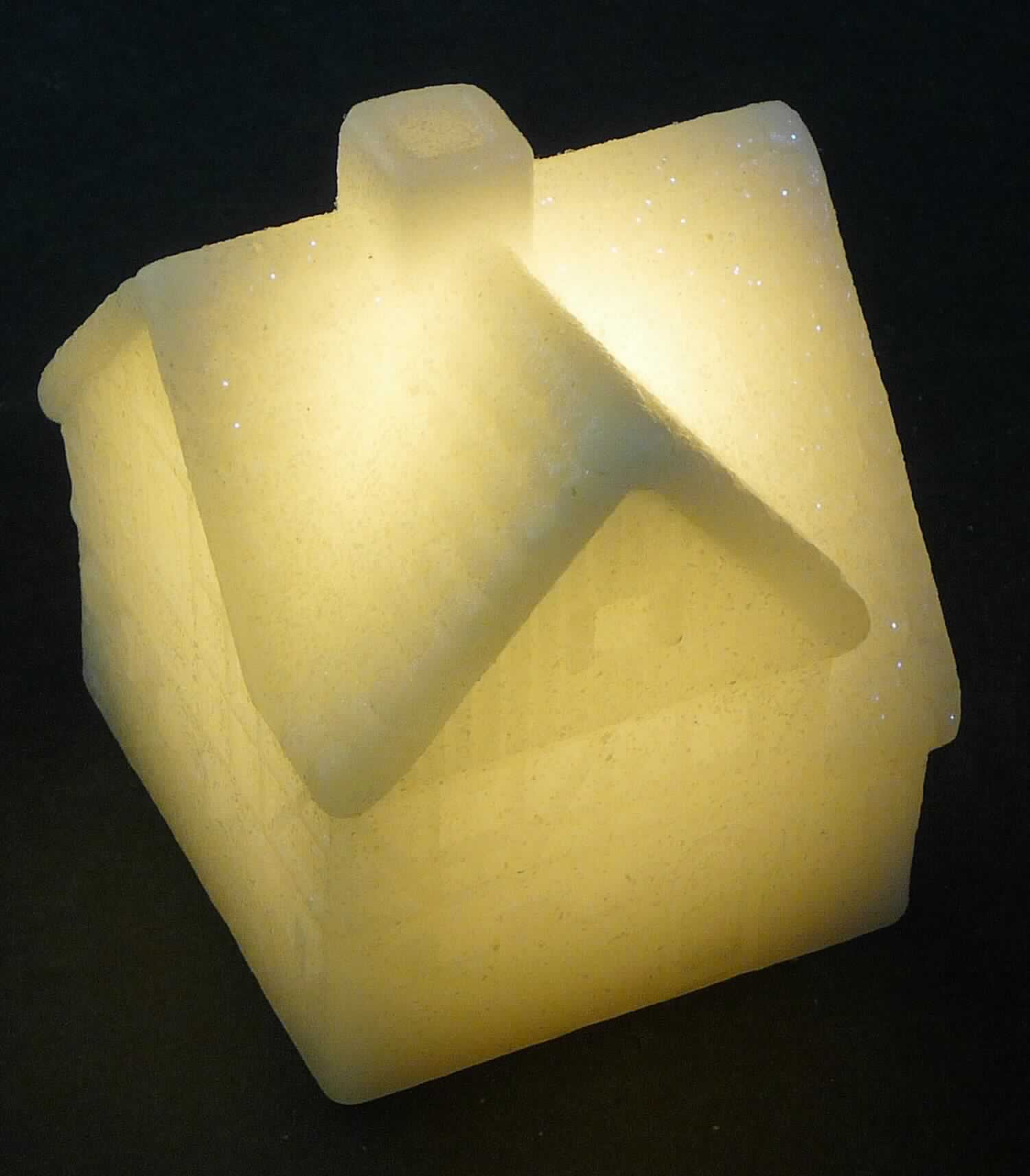 Bei dem sog. "Wachs Deko Haus Triangel Roof" (Art.Nr.: 765502-00) handelt es sich um einen Wachskörper in Form eines Hauses (Höhe ca. 10 cm; Grundfläche: ca. 7 x 7 cm). Im Inneren des Wachskörpers befindet sich eine weiß leuchtende LED. Im Boden befindet sich das mit einem An-/Ausschalter versehene Batteriefach. 

Die Ware stellt sich als Ziergegenstand dar, dessen dekorative Wirkung durch das LED-Licht, das den Wachskörper von innen erhellt, erhöht wird. 
Der Charakter der aus verschiedenen Bestandteilen zusammengesetzten Ware wird insbesondere aufgrund des Umfangs, der Bedeutung für die Verwendung und des Gesamterscheinungsbildes durch den ummantelten Wachskörper bestimmt. Hinweise auf eine Handarbeit liegen nicht vor.

Die Ware ist als "geformte oder geschnitzte Waren aus Wachs, anderweit weder genannt noch inbegriffen, nicht handgearbeitet" einzureihen.