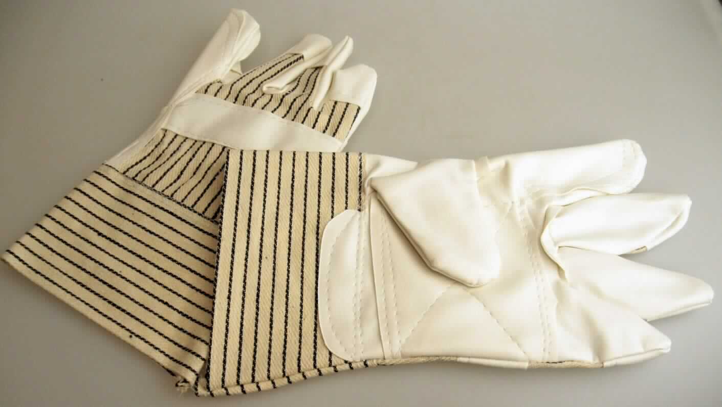 Handschuhe, Artikel 1801911, Größe 10, Foto siehe Anlage,
- als Fünffingerhandschuhe gearbeitet,
- aus unterschiedlichen Flächenerzeugnissen aus lt. Antrag 100 % Baumwolle,
- lt. Untersuchungsergebnis:
-- im Bereich der Innenhand, des Daumens, des Zeigefingers, der Fingerspitzen und der Fingerzwischenräume 
   sowie einem Streifen auf dem Handrücken aus einfarbigen Gewirken der Position 5903, auf der Außenseite mit 
   bloßem Auge wahrnehmbar mit Lagen aus geprägtem Zellkunststoff versehen; die Gewirke sind dicht und dicker
   (ca. 2/3 der Gesamtdicke) als der Zellkunststoff (ca. 1/3 der Gesamtdicke), sie dienen damit nicht nur der 
   Verstärkung, 
-- im Bereich der Stulpe und des restlichen Handrückens aus buntgewebten Geweben,
- am unteren Rand durch Umschlagen und Festnähen gesäumt,
- dienen laut Antrag als Arbeitshandschuhe,
- insbesondere im Hinblick auf die Verwendung als Arbeitshandschuhe bestimmen die Gewirke der Innenhand den 
  Charakter der Ware.

"Fingerhandschuhe aus Gewirken, andere als in der Unterposition 6116 10 genannte, aus Baumwolle"