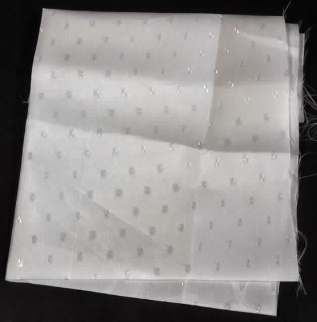 Jacquardgewebe, sog. Gewebe, texturiert Farbe weiß, Foto siehe Anlage,
- als Meterware; mit einer Breite von mehr als 30 cm,
- laut Untersuchungsergebnis:
-- aus ungezwirnten, nicht hochfesten Garnen aus nicht texturierten
   Polyester-Filamenten (synthetische Filamente),
-- in Musterbindung (geometrische Musterung),
-- weiß gefärbt (= gebleicht).

"Gewebe aus Garnen aus synthetischen Filamenten, anderes als in den Unterpositionen 5407 10 bis 5407 54 genannte, mit einem Anteil an nicht texturierten Polyester-Filamenten von mehr als 85 GHT, gebleicht"