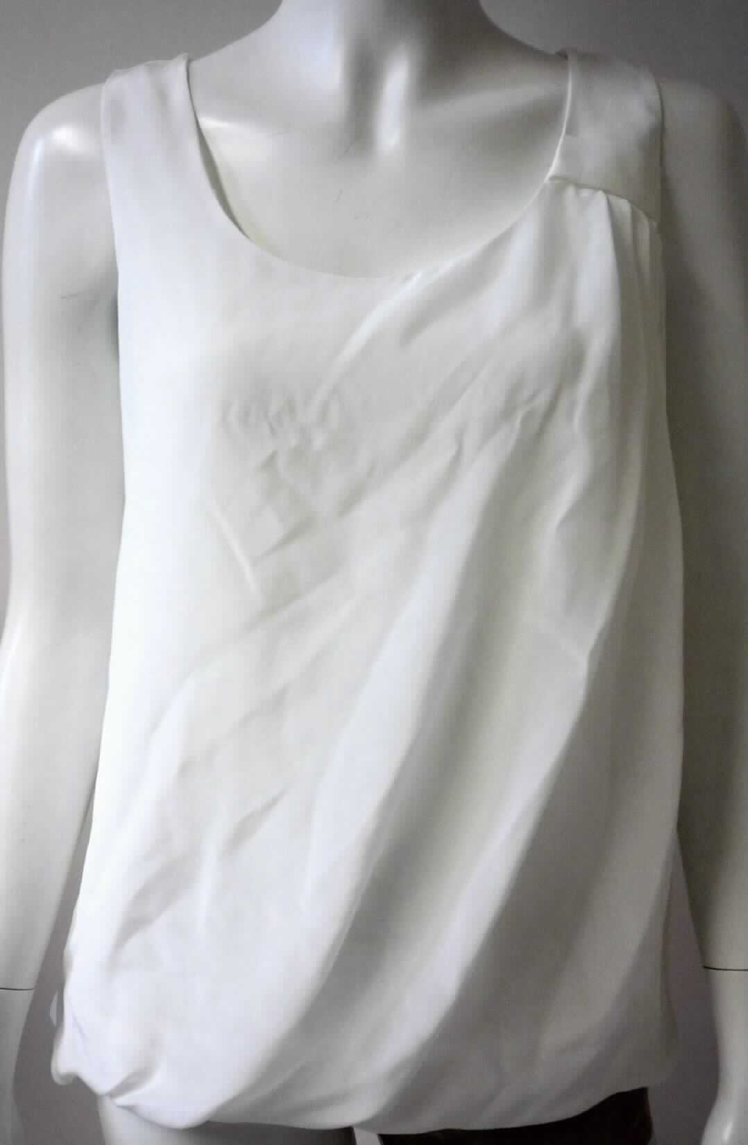 Bluse, sog. Bluse aus 100 % Seide, Größe 36, Foto siehe Anlage,
- zweilagig gearbeitet; mit einer charakterbestimmenden Außenlage aus einfarbigen Geweben aus laut Antrag 
  100 % Seide und einer Innenlage aus einfarbigen Gewirken aus Spinnstoffen; stellt sich aufgrund der 
  Gesamtdicke von ca. 0,5 mm noch als leichtes Kleidungsstück dar,
- über die Taille reichend (Rückenlänge: ca. 60 cm), 
- ohne Öffnung und ohne Verschluss; ohne Hinweise auf den Trägerkreis (unisex),
- ärmellos, mit ca. 4 cm breiten Trägern.

"Bluse, aus Geweben, für Frauen, aus Seide"