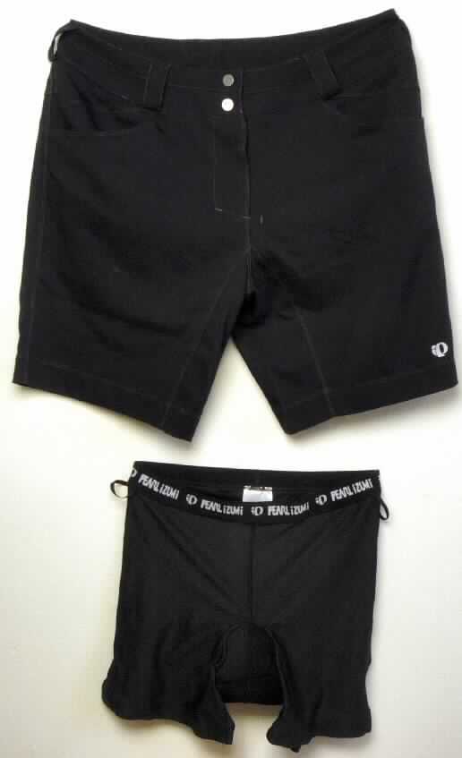 Zwei miteinander verbundene Kleidungsstücke, bestehend aus einer kurzen Hose aus Geweben (außen) und 
einer kurzen Unterhose aus Gewirken (innen), sog. Damenradhose mit Innenhose "W divide Short", 
Art. 11211205, Größe Lage, Foto siehe Anlage,
- beide Kleidungsstücke sind durch Druckknopfriegel am Taillenbund miteinander verbunden, 
  können aber auch separat getragen werden,
- kurze Hose:
- - aus ca. 0,4 mm dicken, einfarbigen Geweben aus lt. Antrag 100 % Polyester 
    (synthetische Chemiefasern),
- - in der Taille abschließend, mit einem angesetzten, etwa 6,5 cm breiten Taillenbund mit 
    Gürtelschlaufen,
- - innen rechts und links mit zwei schmalen Gewebebändern mit Druckknopfverschluss zur
    Befestigung der Innenhose,
- - vorn mit einer Öffnung mit Reißverschluss und Patte, mit zwei Druckknöpfen im 
    Taillenbund von rechts über links zu schließen (Frauenkleidung), 
- - mit zwei eingesetzten Taschen vorn und aufgesetzten Gesäßtaschen,
- - mit kurzen Hosenbeinen, die die Knie nicht bedecken (Seitenlänge: ca. 49 cm),
- - an den Beinabschlüssen durch Umschlagen und Festnähen gesäumt.

"Kurze Hose, aus Geweben, für Frauen, aus synthetischen Chemiefasern, nicht nach dem Batik-Verfahren handbedruckt"