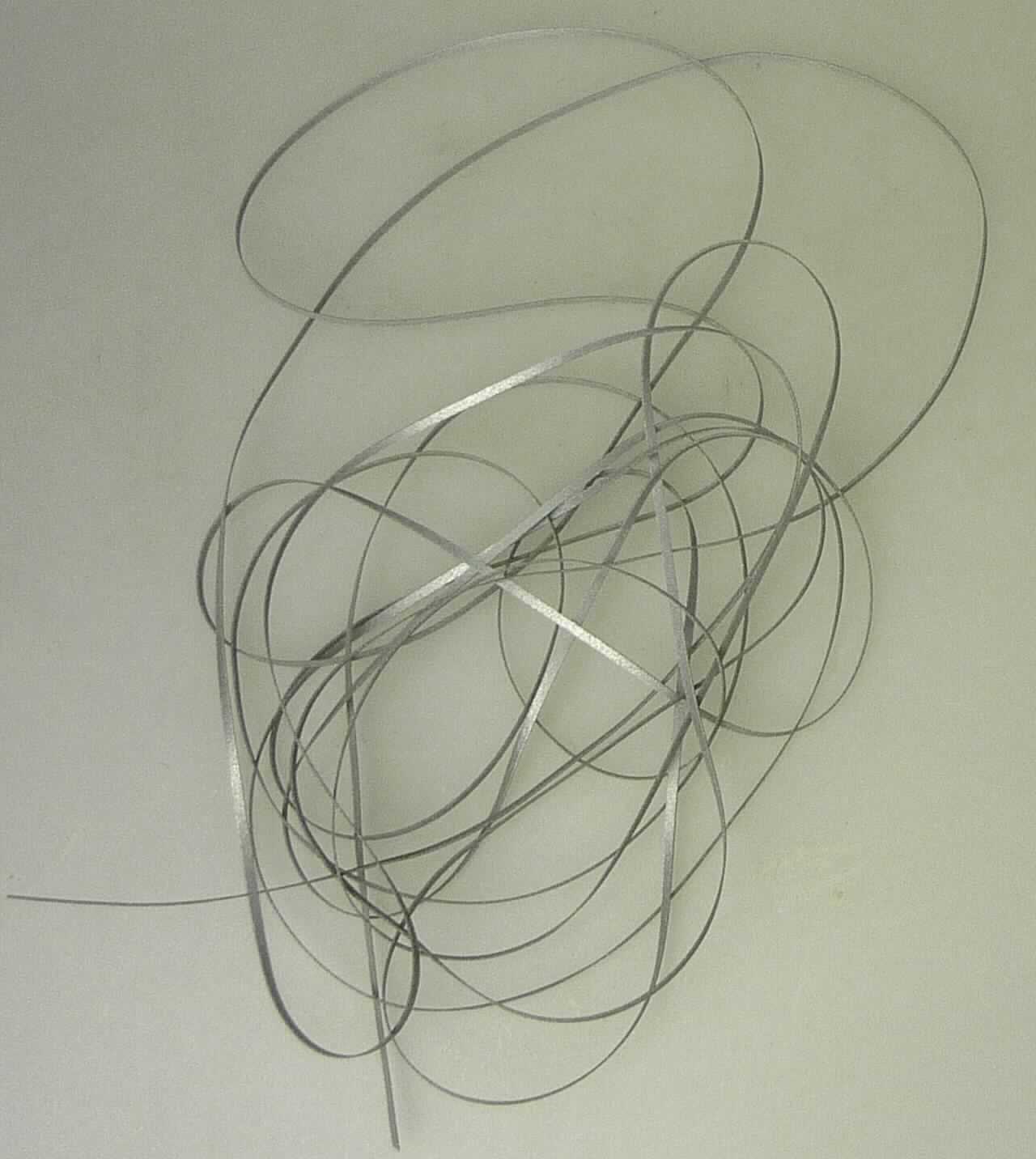 Überzogener Streifen der Position 5404, sog. Polyethylenterephthalat, Foto siehe Anlage,
- als Meterware, 
- augenscheinlich aus einem Streifen aus synthetischer Spinnmasse (laut Antrag aus Polyethylenterephthalat) 
  mit einer Breite von ca. 1 mm (Streifen der Position 5404),
- beidseitig mit dem bloßen Auge wahrnehmbar mit Kunststoff (Klebeschicht) überzogen und mit metallisierten 
  Glaskugeln versehen.

"Streifen der Position 5404, mit Kunststoff überzogen, aus synthetischer Spinnmasse"