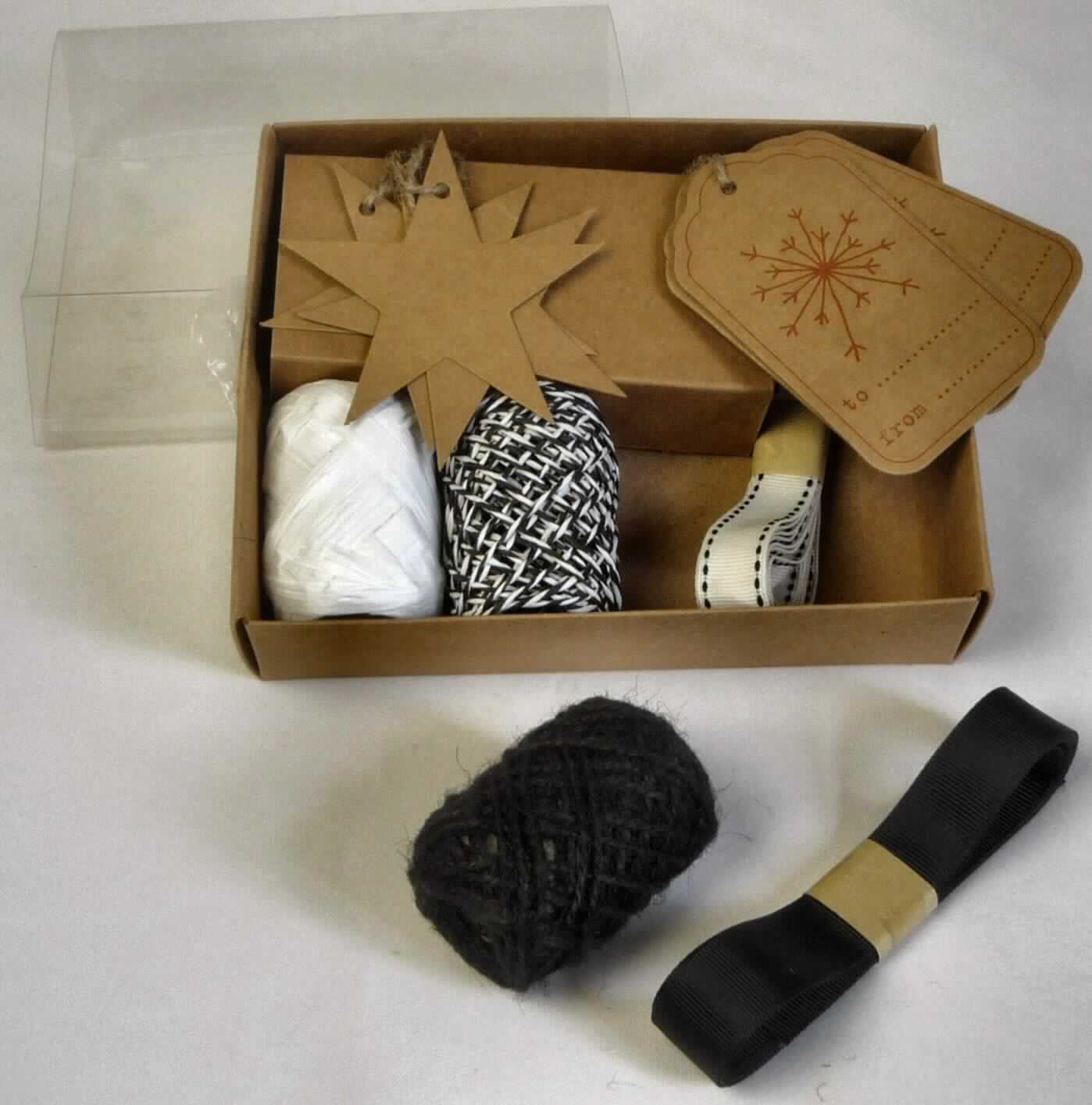Geschenkverpackung, Art. 5517165, Foto siehe Anlage,
- Warenzusammenstellung, bestehend aus Geschenkbändern, unterschiedlichen Geschenkschnüren sowie 
  verschiedenen Geschenkanhängern,
- gemeinsam in einer Schachtel aus Pappe mit einer aufschiebbaren Hülle aus Kunststoff für den Einzelverkauf 
  aufgemacht und zur Befriedigung eines speziellen Bedarfs zusammengestellt,
- Geschenkbänder (weiß und schwarz):
-- als Meterware, mit einer Länge von ca. 200 cm bzw. 180 cm und einer Breite von ca. 15 mm bzw. 20 mm,
-- aus buntgewebten bzw. einfarbigen Geweben aus laut Antrag 100 % Polyester (synthetische Chemiefasern),
-- laut Untersuchung mit echten Webkanten an beiden Längsseiten,
-- kein Samt, Plüsch, Chenille- oder Schlingengewebe,
-- keine Elastomergarne oder Kautschukfäden enthaltend,
- Geschenkschnüre:
-- Papiergarn (schwarz/weiß):
--- als Meterware im "Eiknäuel",
--- laut Untersuchung aus einem gezwirnten Garn aus gefalteten und gedrehten Papierstreifen,
--- ohne Metalldrahtverstärkung,
-- Garn (schwarz):
--- als Meterware im "Eiknäuel",
--- laut Antrag aus Jute (diese Angabe kann als zutreffend angesehen werden),
--- laut Untersuchung:
---- zweifach gezwirntes Garn,
---- weder poliert noch glasiert, 
---- mit einem Titer von 7530 dtex,
-- Papierstreifen (weiß):
--- als Meterware im "Eiknäuel",
--- laut Untersuchung:
---- aus einem weißen, in Längsrichtung gefalteten Streifen aus Papier,
---- mit weniger als 10 Drehungen pro Meter,
- Geschenkanhänger:
-- Anhänger "Schneeflocke":
--- annährend rechteckig, in den Abmessungen: ca. 9,5 cm x 5,5 cm,
--- aus Pappe,
--- am oberen Rand mit einer Aufhängevorrichtung,
--- mit Aufdrucken: stilisierte Schneeflocke sowie "to ....." und "from .....",
-- Anhänger "Stern":
--- sternförmig, mit einem Durchmesser von ca. 8 cm,
--- aus Pappe,
--- am oberen Rand mit einer Aufhängevorrichtung,
- im Hinblick auf die Bedeutung in Bezug auf die Verwendung sind alle Bestandteile der Warenzusammenstellung
  als gleich zu betrachten, im Hinblick auf den Wert verleihen die Bänder der Warenzusammenstellung den 
  wesentlichen Charakter, im Hinblick auf die Anzahl sind die Anhänger "Stern" und der Papierstreifen 
  charakterbestimmend, damit verleihen weder die Bänder noch die Anhänger "Stern" und der Papierstreifen der 
  Warenzusammenstellung ihren wesentlichen Charakter; sie ist damit der von den gleichmaßen in Betracht 
  kommenden  Position (4823 bzw. 5806) in der Nomenklatur zuletzt genannten zuzuweisen.

"Band, keine Ware der Position 5807, kein Samt, Plüsch, Chenille- oder Schlingengewebe, keine Elastomergarne 
 oder Kautschukfäden enthaltend, aus Chemiefasern, mit echten Webkanten"
