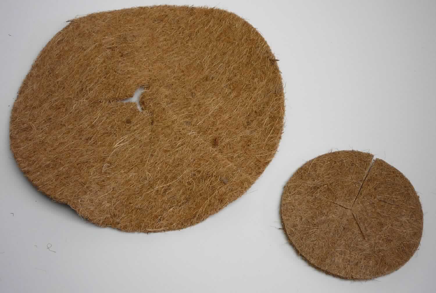 Mulchscheibe Baumschutz/ Topfabdeckung, Foto siehe Anlage,
- rund zugeschnitten (somit konfektioniert), mit einem Durchmesser von ca. 13 cm bzw. 30 cm,
- zur Mitte hin an einer Stelle eingeschnitten und in der Mitte mit einer kreisrunden Aussparung versehen,
- lt. Untersuchungsergebnis:
-- aus Nadelfilz aus Kokosfasern,
-- einseitig mit lt. Antrag Kautschuk bestrichen bzw. besprüht,
- mit einem Anteil des Spinnstoffs von über 50 GHT,
- wird laut Antrag im Gartenbereich als Abdeckung verwendet.

"Andere konfektionierte Ware (Abdeckung), aus Spinnstoffen, aus Filz"