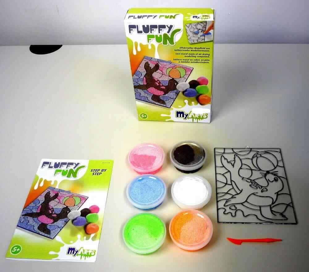Angaben: 
My Arts Fluffy Fun, Zusammenstellung verschiedenfarbiger Knetmassen zum Herstellen eines effektvollen Wandbilds und weiterer lustiger Sachen.

Warenbeschreibung: 
Warenzusammenstellung aus sechs körnigen Knetmassen in Dosen (Farben: weiß, rosa, orange, grün, blau, braun), einer Gebrauchsanleitung, einem in Kunststofffolie verpackten, durchsichtigen Fensterbild (mit integrierter Aufhängevorrichtung und aufgedrucktem Seehund-Motiv, ca. 13 x 17 cm) aus Kunststoff und einem kleinen, orangefarbenen Kunststoffspatel, zusammen verpackt in einer Pappfaltschachtel in Aufmachung für den Einzelverkauf.  

Befund: 
Warenzusammenstellung, bei der im Hinblick auf die Menge, Umfang und Bedeutung in Bezug auf den Verwendungszweck die Knetmasse den charakterbestimmenden Bestandteil darstellt.
Zusammenstellung von Modelliermassen, zur Unterhaltung von Kindern.