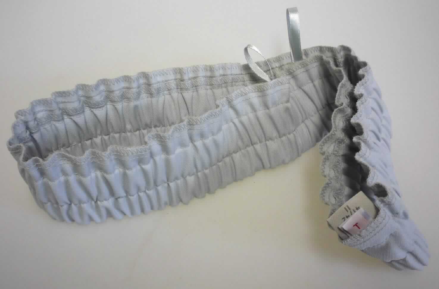 Teil von Kleidung, sog. Bund mit Gummizug, Art. 90044, Foto siehe Anlage 
- aus ca. 0,5 mm dicken, einfarbigen Geweben aus laut Antrag 65 % Polyester (synthetische Chemiefasern) 
  und 35 % Baumwolle,
- in den Abmessungen: etwa 42 cm x 6 cm, 
- mit einem fest eingenähten Einsatz aus einem gummielastischen "Band",	 
- mit zwei Aufhängeschlaufen ausgestattet, 
- durch Zusammennähen konfektioniert, 
- ist laut Antrag dazu bestimmt, als Bund von Hosen Verwendung zu finden, 
- stellt sich aufgrund der speziellen Form und Beschaffenheit als erkennbares Teil von Kleidung dar. 

"Teile von Kleidung, aus Spinnstoff, andere als solche der Position 6212"