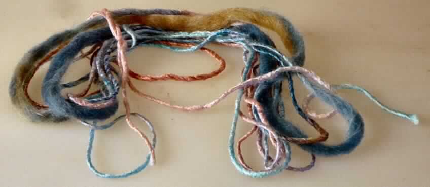 Garn, sog. Handstrickgarn "Flambé", Foto siehe Anlage,
- lt. Antrag als Meterware in einem Knäuel aufgemacht,
- lt. Untersuchungsergebnis:
-- gedrehtes, meliertes Garn (sog. Flammengarn); nicht gezwirnt, somit kein Nähgarn,
-- aus künstlichen Spinnfasern (Viskose) und synthetischen Spinnfasern (Polyacryl; glänzende Garnstellen) 
   sowie Wolle (dicke, matte Garnstellen; sog. Flammenabrisse); aufgrund der Garnkonstruktion kein Bindfaden
   der Position 5607,
-- mit einem Anteil an künstlichen Spinnfasern von 48 GHT, an synthetischen Spinnfasern von 8 GHT und an 
   Wolle von 44 GHT (die Antragsangaben können als zutreffend angesehen werden),
-- in Aufmachung für den Einzelverkauf (als Knäuel mit einem Gewicht von 50 g).

"Garn aus künstlichen Spinnfasern, kein Nähgarn, in Aufmachung für den Einzelverkauf"