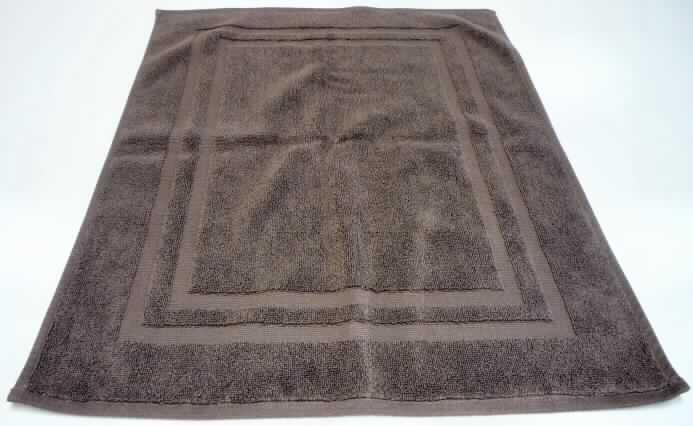 Fußbodenbelag (Badvorleger), sog. Duschvorleger, Kat. 4905, NAN0925493, siehe beigefügtes Foto,
- rechteckig, in den Abmessungen: ca. 50 x 70 cm,
- Dicke: ca. 5,5 mm,
- aus musterbildenden Schlingengeweben (Frottiergeweben) aus lt. Antrag 100% Baumwolle; auf
  einer Seite sind die Schlingen Muster bildend entfernt worden,
- an den Rändern durch Umschlagen und Festnähen gesäumt (= konfektioniert),
- kennzeichnet sich durch seine Festigkeit, Dicke und Steifheit als Fußbodenbelag.
- aufgrund des Verwendungszwecks und der Materialbeschaffenheit keine Ware der
  Position 6302 (Wäsche zur Körperpflege).

"Fußbodenbelag, aus Spinnstoffen, gewebt, weder getuftet noch beflockt, kein Kelim, 
 Sumak, Karamanie und ähnliche handgewebte Teppiche, mit Flor, konfektioniert, aus 
 Baumwolle"