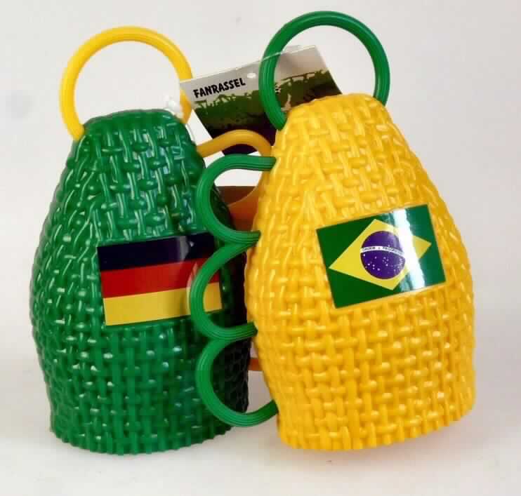 Es handelt sich um ein Set aus 2 Stück den Maracas ähnlichen Schlaginstrumenten in Form von halbovalen und hohlen Klangkörpern aus grünem bzw. gelbem Kunststoff, die mit kleinen Kunststoffkugeln befüllt sind, welche beim Schütteln einen lauten Ton erzeugen. Die ca. 14 cm langen, im Durchmesser ca. 10 cm großen und z.B. bei Fußballveranstaltungen verwendeten Fanrasseln sind seitlich mit einem Handgriff ausgestattet und auf der Vorderseite mit einer Länderflagge verziert (Deutschland bzw. Brasilien).

Mittels Kunststoffbinder, an dem sich ein bunt bedrucktes Produkschild befindet, werden die beiden Rasseln als Set angeboten und sind als "Schlaginstrumente" einzureihen.

Anlage: 1 Abbildung