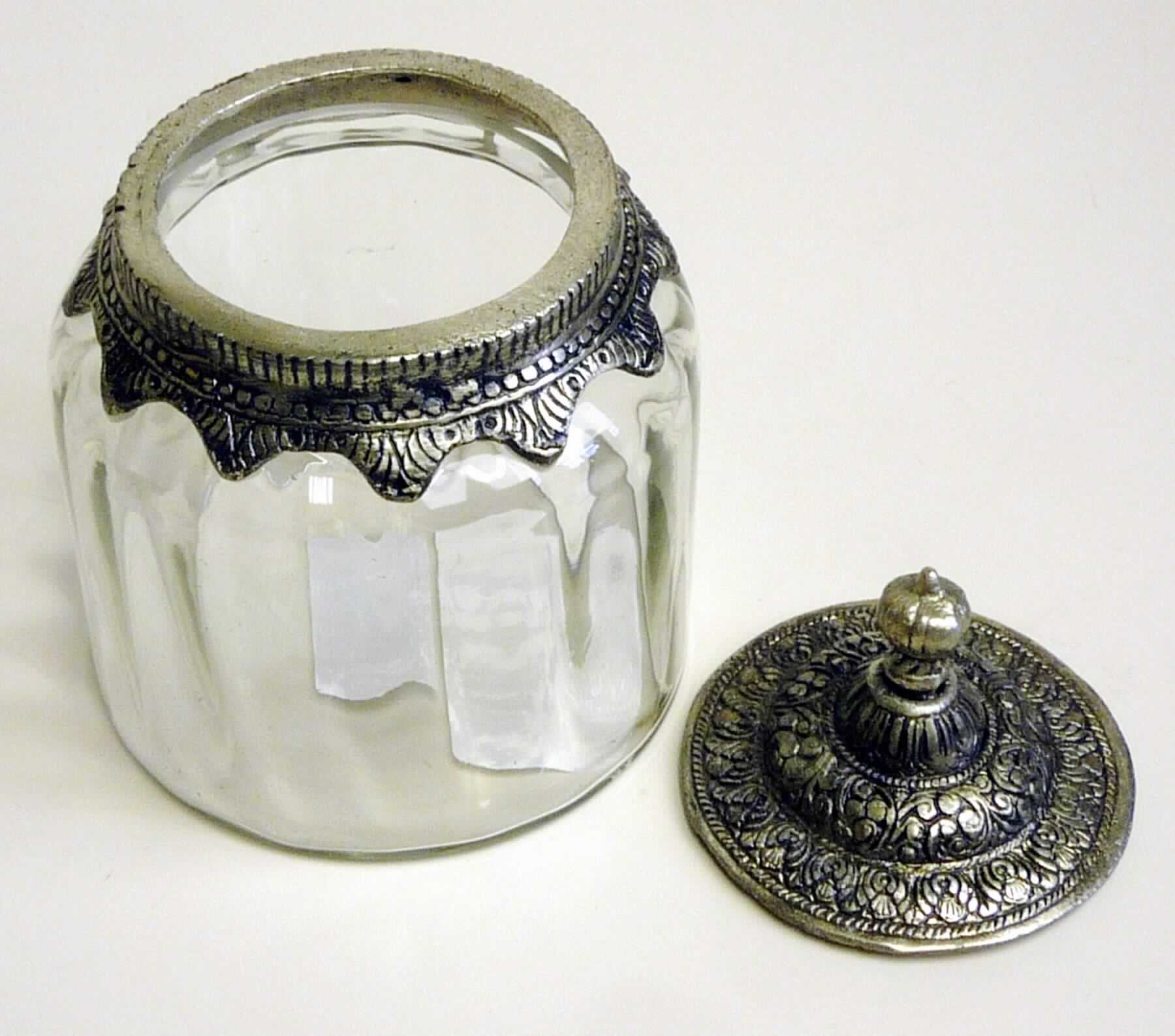 Glasware zur Verwendung bei Tisch, sog. Glasbehälter mit Deckel, Foto siehe Anlage, 
- bestehend aus einem aus verschiedenen Stoffen zusammengesetzten Gefäß mit Deckel,
- in den Abmessungen: ca. 12 cm (Durchmesser) x 17 cm (Höhe),
- Gefäß:
- - Glasgefäß mit Rillenstruktur, 
- - laut Antrag aus gewöhnlichem, handgefertigtem Glas, 
- - oben offen; am oberen Rand mit einer Verzierung aus laut Antrag Aluminium (unedles Metall) eingefasst,
- Deckel:
- - laut Antrag aus Aluminium,
- - ornamentartig verziert,
- stellt sich als Ware zur Verwendung bei Tisch (z. B. als Bonbonniere) dar,
- im Hinblick auf den Wert, den Umfang und den Verwendungszweck bestimmt das Glas den Charakter der Ware.

"Glasware zur Verwendung bei Tisch oder in der Küche, aus gewöhnlichem Glas, handgefertigt"