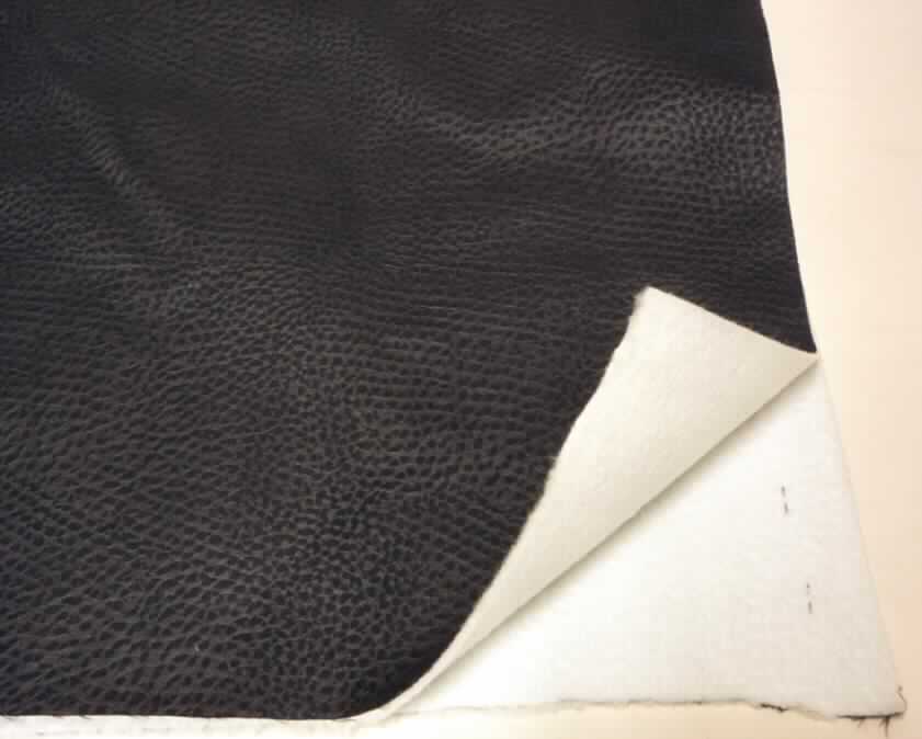 Textillaminat, sog. Möbelbezugsstoff, Foto siehe Anlage,
- als Meterware,
- mit einer Breite laut Antrag von 144 cm,
- aus zwei mit ihrer ganzen Fläche aufeinanderliegenden und so miteinander durch Kleben verbundenen Lagen:
-- Oberlage: aus einem geschmirgelten, geprägten, gefärbten, atlasbindigen Gewebe aus ungezwirnten,
   nicht hochfesten Garnen aus ca. 60 GHT synthetischen Filamenten (laut Antrag: Polyester) und
   ca. 40 GHT synthetischen Spinnfasern (laut Antrag: Polyester); die Schauseite bildend,
-- Unterlage: aus einem weißen, gerauten Kuliergewirke aus synthetischen Chemiefasern;
   keine Elastomergarne oder Kautschukfäden enthaltend, 
- insbesondere in Bezug auf die Verwendung (Möbelbezugsstoff) bestimmt das die Schauseite bildende Gewebe
  den Charakter der Ware.

"Textillaminat aus Gewebe aus Garnen aus synthetischen Filamenten (charakterbestimmend), 
 anderes als in den Unterpositionen 5407 10 bis 5407 84 genannte, gefärbt und aus Gewirke"