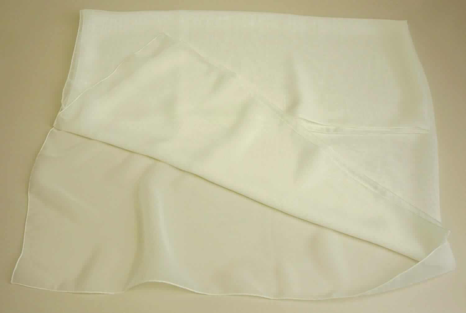 Umschlagtuch, sog. Chiffon Stola, Art. 2250 ivory, Foto siehe Anlage,
- aus ca. 0,2 mm dicken, einfarbigen, durchscheinenden Geweben aus laut Antrag synthetischen Chemiefasern,
- rechteckig, in den Abmessungen von ca. 212 cm x 72 cm,
- an allen Rändern durch Überwendlichnähte gesäumt (somit konfektioniert),
- ohne Hinweise auf Handarbeit.

"Umschlagtuch, aus Geweben, aus synthetischen Chemiefasern, nicht handgearbeitet"