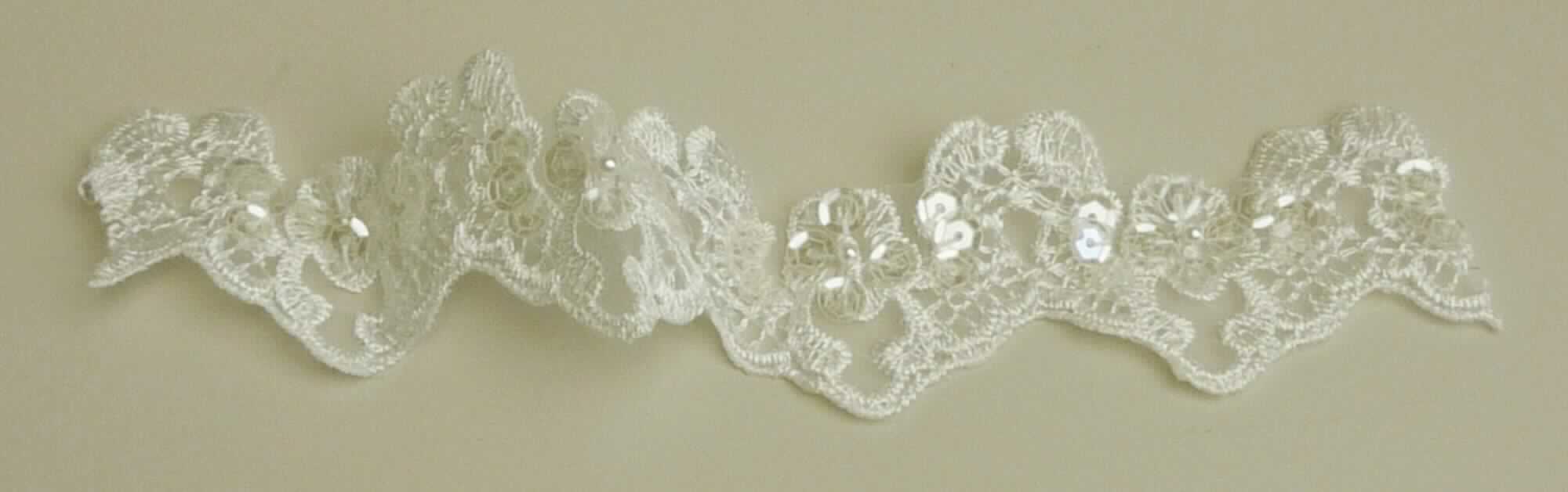Applikationsstickerei, sog. Schleierspitze, Art. 2331 ivory, Foto siehe Anlage,
- laut Antrag als Meterware,
- mit einem Stickgrund aus undichten Geweben aus laut Antrag Chemiefasern,
- auf diesem Grund sind mittels Stickfäden sowie Pailletten und Perlen aus Kunststoff Muster aufgestickt,
- laut Antrag mit einem Wert von mehr als 17,50 Euro je kg Eigengewicht,
- ohne Hinweise auf Handarbeit.

"Stickerei als Meterware, keine Ätzstickereien und Stickereien mit herausgeschnittenem Grund, aus Chemiefasern,
 mit einem Wert von mehr als 17,50 Euro je kg Eigengewicht, nicht handgearbeitet"