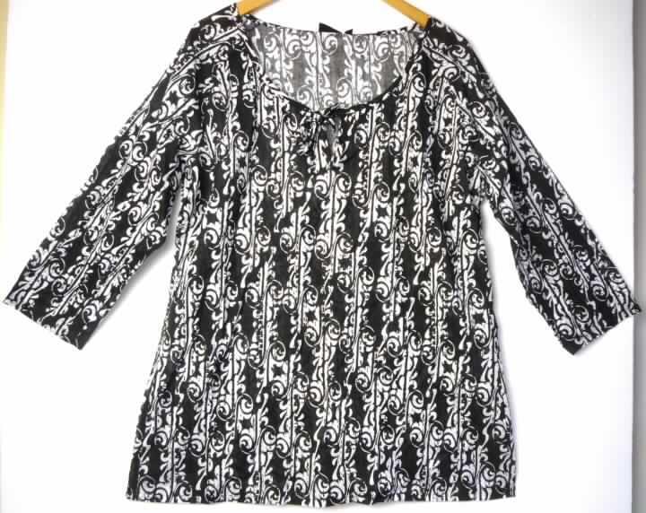 Hemdbluse für Frauen, sog. Damen Tunika 0913559, Kat. 4076, Style 1, Größe L, Foto siehe Anlage,
- aus 0,3 mm dicken, maschinell bedruckten Geweben aus laut Antrag 100 % Baumwolle,
- über den Schritt reichend (Rückenlänge: 74 cm), 
- mit einem runden, halsfernen Ausschnitt,
- vorn mit einer kurzen Öffnung, die mit einem Bindeband geschlossen wird,
- mit Brustabnähern, daher als Frauenkleidung erkennbar; mit halblangen Ärmeln, 
- den Hemden für Männer entsprechend zugeschnitten,
- an den Ärmelenden und am unteren Rand gesäumt.

"Hemdbluse aus Geweben, für Frauen, aus Baumwolle, nicht nach dem Batik-Verfahren handbedruckt"