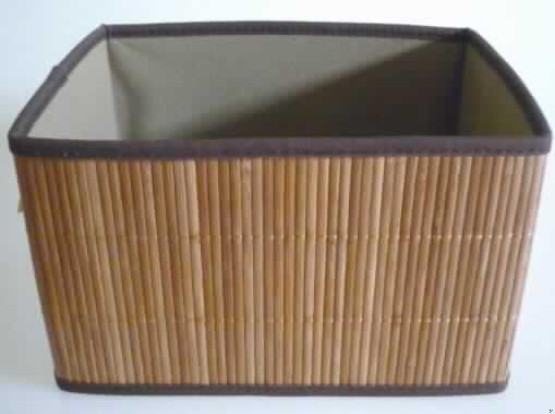 Aufbewahrungsbox aus Flechtstoffen (sog. Bambus Box) 
- zusammenklappbar gestaltet,
- in den Abmessungen (L x B x H) von ca. 25 x 20 x 15 cm,
- an den Außenseiten der Seitenteile aus pflanzlichen Flechtstoffen hergestellt
  (aus parallel aneinandergefügten Bambusstreifen (Breite ca. 5 mm), die nebeneinander 
  gelegt und durch Haltefäden aus Spinnstoffgarnen in Flächenform verbunden sind), 
- an den Rändern der Außenseiten mit einem ca. 1 cm breiten Band aus Spinnstoffgewebe 
  eingefasst, 
- mit einer starren Zwischenlage aus Pappe und einem Innenfutter aus Vliesstoffen 
  (Spinnstoff) versehen,
- mit einer Unterseite aus Spinnstoffgewebe ausgestattet, die mit einem an drei Seiten 
  umlaufenden Reißverschluss zum leichteren Zusammenklappen der Box versehen ist,
- innen mit einem lose eingelegten Bodenteil aus beidseitig mit Vliesstoffen überzogener
  Pappe verstärkt,
- ohne Hinweise auf Fertigung in Handarbeit.
Nach Gesamteindruck verleihen die pflanzlichen Flechtstoffe aus Bambus der Ware ihren Charakter.