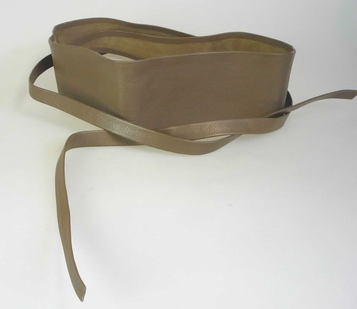 Bekleidungszubehör (Gürtel) aus Leder, sog. Wickelgürtel Nappa Leder, Art. HW10-03975, Foto siehe Anlage, 
- lt. Antrag aus Leder,
- als Wickelgürtel gearbeitet,
- aus einem bis zu 7,5 cm breiten und ca. 105 cm langen Lederstreifen, der an den Enden spitz zuläuft und
  beidseitig mit ca. 50 cm langen, schmalen Lederstreifen versehen ist (zum Zusammenbinden),
- mit einem ca. 2 cm langen Schlitz ausgestattet, durch den einer der beiden schmalen Lederstreifen zum
  Zusammenbinden geführt wird,
- ohne Hinweise auf Handarbeit.

"Bekleidungszubehör (Gürtel) aus Leder, nicht handgearbeitet"