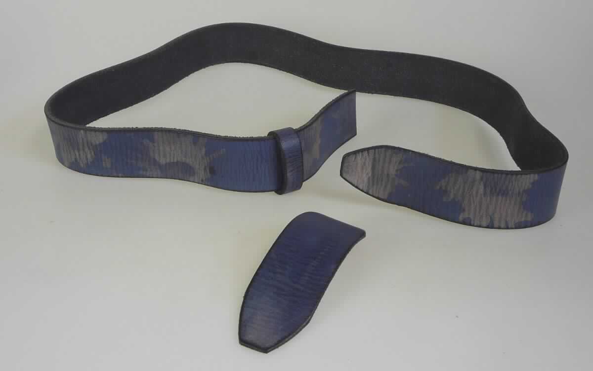 Bekleidungszubehör aus Leder (Gürtel), sog. Büffellederrohling, Art. RO39-2573A, Foto siehe Anlage,
- in Form einer unfertigen (u. a. fehlende Gürtellöcher), unvollständigen (u. a. fehlende Gürtelschnalle), noch
  nicht zusammengesetzten Ware im Sinne der AV 2 a), die wie die fertige Ware einzureihen ist,
- aus lt. Antrag Leder,
- bestehend aus:
- - einem ca. 107 cm langen und ca. 4 cm breiten Streifen; an einem Ende lediglich gerade abgeschnitten,
    am anderen Ende spitz zulaufend; erkennbar zur Herstellung von Gürteln bestimmt,
- - einer Lederschlaufe (durch die das Gürtelende geführt wird) aus einem ca. 1,4 cm breiten Streifen, der
    an den Enden durch drei Klammern aus unedlem Metall verbunden ist,
- - einem sog. Kapplochteil mit abgerundeten Enden (an dem die Gürtelschnalle befestigt wird) mit einer Länge
    von ca. 13 cm und einer Breite von ca. 4 cm, 
- ohne Hinweise auf Handarbeit.

"Bekleidungszubehör (Gürtel), aus Leder, nicht handgearbeitet"
