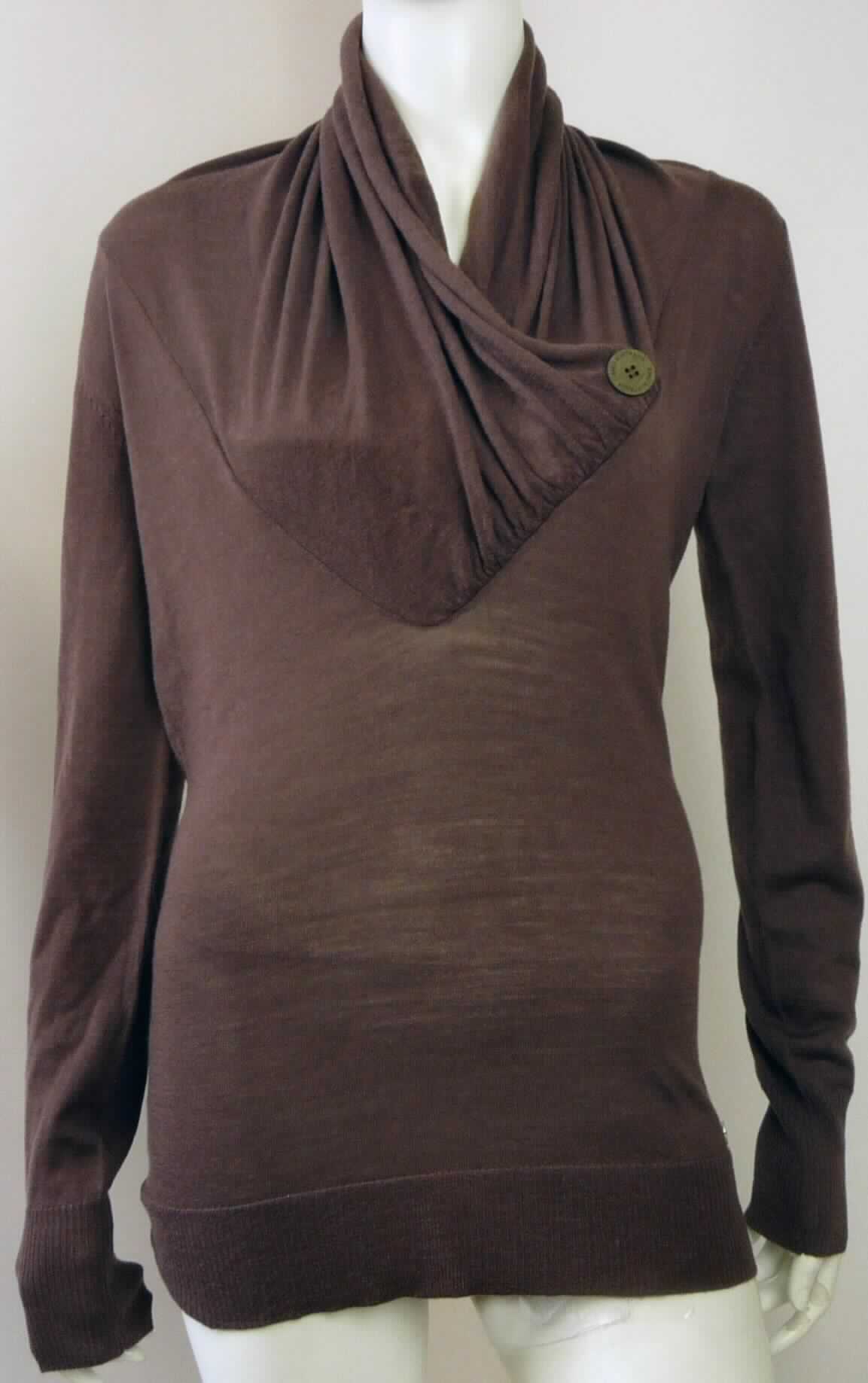 Kleidung, sog. MT Bogong Pullover, Artikel Nr. W03080, Größe S, Foto siehe Anlage,
- aus ca. 0,8 mm dicken, einfarbigen Gewirken aus lt. Antrag 100 % Merinowolle,
- über den Schritt reichend (Rückenlänge: ca. 70 cm),
- vorn mit einem V-förmigen, nicht sehr tiefen Halsausschnitt, der wasserfallartig aufliegt, durch einen Zierknopf
  aus augenscheinlich Holz auf der linken Seite fixiert ist, eine Überlappung von rechs über links bildet und 
  lediglich im Nackenbereich in Art eines Rollkragens, der sich nicht als pullovertypischer Kragen darstellt, 
  gearbeitet ist (somit weder eine Bluse der Position 6106, ein Kleidungsstück der Position 6109, noch ein 
  Pullover der Position 6110), 
- ohne Öffnung und ohne Verschluss,
- mit langen Ärmeln mit gerippten Abschlüssen,
- am unteren Rand mit einem nicht verengenden Bund aus gerippten Gewirken.

"Kleidung, andere als in den Positionen 6101 bis 6113 genannte, aus Gewirken, aus Chemiefasern"