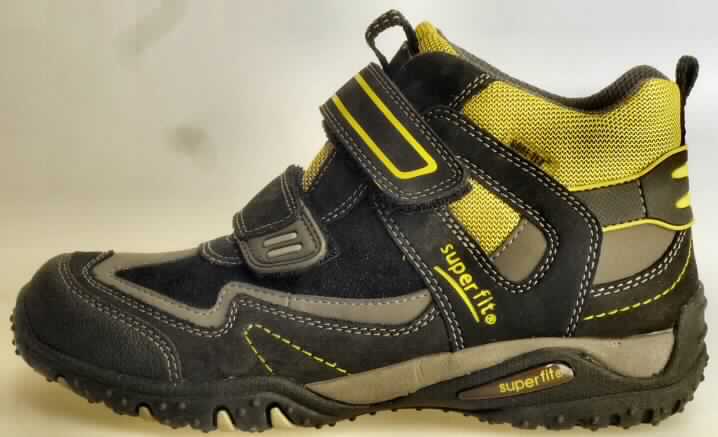 Trainingsschuhähnliche Schuhe (lt. Antrag: "Kindertrainingsschuh; Art. 363/9 Größe 33", Foto siehe Anlage)
- mit Laufsohlen aus (lt. Antrag) Kautschuk; ohne Hauptsohle aus Holz,
- mit Oberteil (geschlossenes Blatt) aus Leder (den größten Teil der Außenfläche bildend),
  Kunststoff (Spinnstoff mit einer mit dem bloßen Auge wahrnehmbaren Außenschicht aus 
  Kunststoff) und Spinnstoff,
- auf das Oberteil sind Stücke aus Kunststoff als Verstärkungsteile aufgesetzt,
- mit Klettverschluss,
- nicht mit Dornen, Krampen, Klammern, Stollen oder ähnlichen Vorrichtungen
  versehen oder für deren Anbringung hergerichtet (keine Sportschuhe),
- ohne Schutz in der Vorderkappe,
- den Knöchel, jedoch nicht die Wade bedeckend,
- mit einer Länge der Innensohle von weniger als 24 cm,
- nach Spezialtechniken hergestellt, mit einem cif-Preis je Paar (lt. Antrag) 
  von mehr als 7,50 Euro, mit mehrlagiger, geformter, stoßdämpfende Eigenschaften 
  aufweisender Sohle aus synthetischen Stoffen

"Schuhe mit Laufsohlen aus Kautschuk und Oberteil aus Leder, andere als in den UPos.
6403 1200 bis 6403 9105 genannt, den Knöchel, jedoch nicht die Wade bedeckend, mit
einer Länge der Innensohle von weniger als 24 cm, nach Spezialtechniken hergestellt"