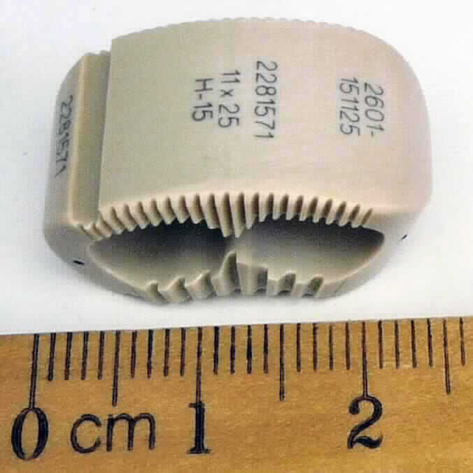 Wirbelsäulenimplantat (Cage), sog. Zwischenwirbelersatz (ZWE) "TraXis", Art.-Nr. 2601-151125, im Wesentlichen bestehend aus einem anatomisch, konvex geformten, befüllbaren Körper aus röntgendurchlässigem PEEK-Optima Material, in welchen Röntgenmarkerungen (Tantaldrähte) eingearbeitet sind. Es ist eine an zwei einander gegenüberliegenden Flachseiten texturierte hohle Vorrichtung, die in unterschiedlichen Formen und in verschiedenen Längen, Breiten und Höhen verfügbar ist. 
Äußere Form: siehe Abbildung in der Anlage.
Die Ware wird im Rahmen der Behandlung von Erkrankungen im Bereich der Brust-Lenden-Wirbelsäule als Abstandshalter in den Bandscheibenzwischenraum in den menschlichen Körper implantiert und dient der Distraktion des Bandscheibenraumes und der Wiederherstellung der Bandscheibenhöhe. Die Cages sind für die Behandlung von degenerativen Bandscheibenerkrankungen, Bandscheibenvorfällen, Foramenstenosen. Tumoren, Traumen, Deformationen (einschließlich Skoliose, Spondylolisthese und Retrolisthese) und bei Fehlschlagen früherer Fusionen vorgesehen.
Das Implantat ist  steril in einer Box mit beiliegender Infobroschüre verpackt.

Die Ware wird als "künstliches Körperteil für Menschen, nicht von den Unterpositionen (KN) 9021 1010 bis 9021 3910 erfasst" eingereiht.