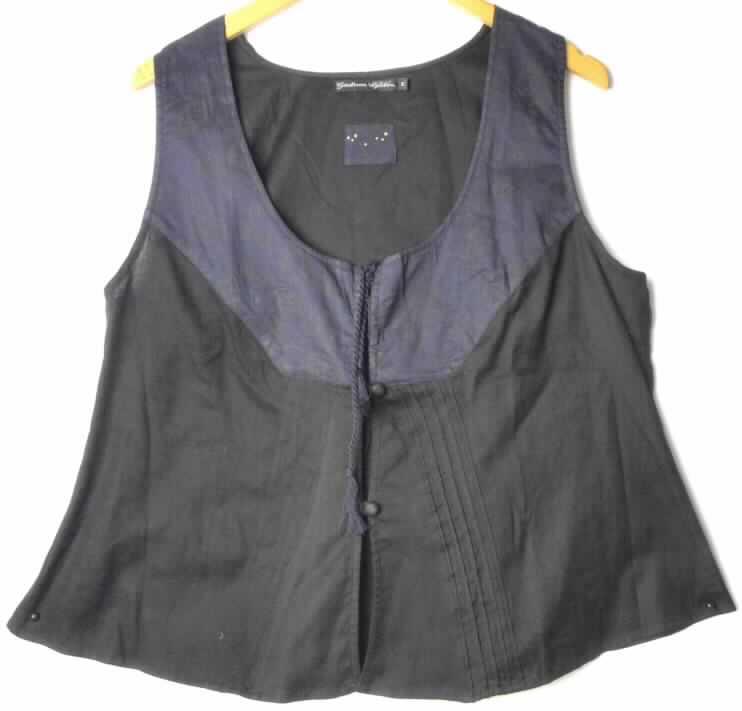 Bluse für Frauen, sog. Damen Shirt (Art. 07-604), Größe M, Foto siehe Anlage,,
- aus 0,4 mm dicken, leichten, einfarbigen Geweben aus laut Antrag 100% Baumwolle,
- über die Taille reichend (Rückenlänge: 61 cm), 
- mit einem runden, halsfernen Ausschnitt, mit einem Bindeband zu schließen,
- entlang des Ausschnitts mit einer bis zu 13 cm breiten, aufgenähten Lage aus 0,2 mm dicken, bedruckten 
  Geweben verziert (nicht handbedruckt),
- vorn mit einer durchgehenden Öffnung mit zwei Knöpfen von rechts über links zu schließen (Frauenkleidung),
- ärmellos, mit nicht sehr weiten Armausschnitten,
- weit geschnitten, nach unten ausgestellt,
- vorn mit Biesen, im Rückenteil mit Plisseefalten gearbeitet; modisch gestaltet,
- am unteren Rand gesäumt.

"Bluse aus Geweben, für Frauen, aus Baumwolle, nicht nach dem Batik-Verfahren handbedruckt"