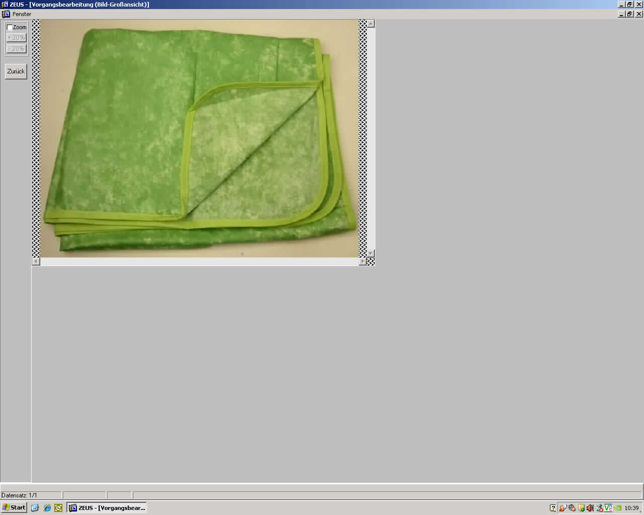 Tischwäsche, Muster 2, Foto siehe Anlage,
- quadratisch; mit einer Seitenlänge von etwa 100 cm,
- aus ca. 0,3 mm dicken, einfarbig bedruckten Geweben aus laut Antrag 50% Polyester (synthetische 
  Chemiefasern) und 50 % Baumwolle,
- einseitig, mit bloßem Auge nicht wahrnehmbar mit Kunststoff (laut Antrag Acryl) beschichtet,
- mit einem schmalen Gewebestreifen eingefasst (u. a. damit konfektioniert),
- wird üblicherweise gewaschen und kennzeichnet sich nach Verwendungszweck und Materialbeschaffenheit 
  als Tischwäsche.

"Tischwäsche, aus Spinnstoffen, aus Geweben, aus Chemiefasern"