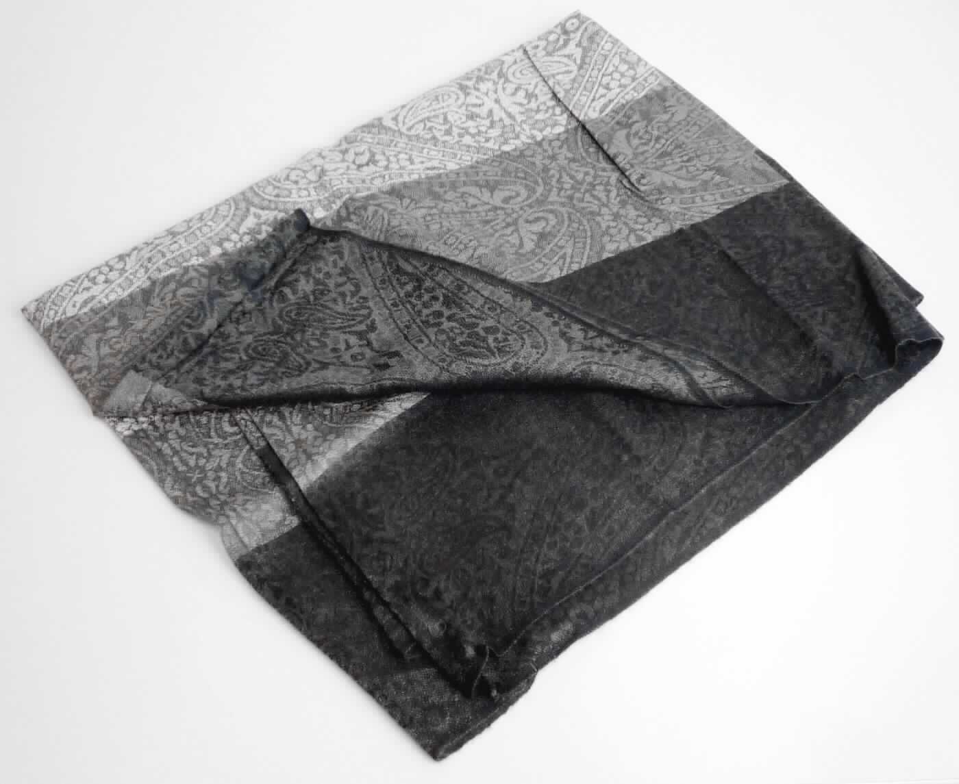 Schalähnliche Ware, sog. Jaquard-Loops, Foto siehe Anlage,
- in einem Polybeutel verpackt,
- aus ca. 0,4 mm dicken, buntgewebten Geweben aus laut Antrag 55 % Acrylic (synthetische Chemiefasern)
  und 45 % Viskose (künstliche Chemiefasern),
- flachliegend mit einem Durchmesser von laut Antrag ca. 80 cm und einer Breite von ca. 70 cm,
- an den Längsseiten mit echten Webkanten,
- an den Schmalseiten zu einem "Rundschal" zusammengenäht (u. a. somit konfektioniert),
- wird in der Art eines Schals um den Hals getragen,
- ohne Hinweise auf Handarbeit,
- individuelles (selbstständiges) Einzelstück, das eine Ergänzung von Kleidung darstellt.

"Schalähnliche Ware, aus Geweben, aus synthetischen Chemiefasern, nicht handgearbeitet"