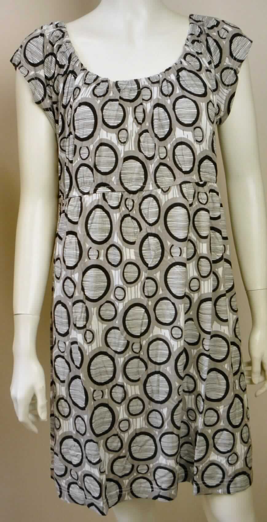 Kleid, sog. Damen Longshirt/ Kleid 153822/154120, Größe S, M und L, Foto siehe Anlage,
- veranschaulicht durch ein Warenmuster in der Größe L,
- verpackt in einem Polybeutel mit Pappeinleger,
- aus ca. 0,6 mm dicken, bedruckten (schwarz/grau/weiß) Gewirken aus laut Antrag 100 % Viskose 
  (künstliche Chemiefasern), 
- über den Schritt reichend (Rückenlänge: etwa 85 cm); kann aufgrund der Länge ohne ein weiteres, den 
  Unterkörper bedeckendes Kleidungsstück getragen werden,
- mit einem runden, halsfernen Ausschnitt; am Rand mit einem eingenähten, elastischen Band gerafft,
- mit sehr kurzen Ärmeln (sog. überschnittenen Schultern),
- ohne Öffnung und ohne Verschluss, 
- unterhalb der Brust mit einem eingenähten, elastischen Band ausgestattet, 
- am unteren Ende und an den Ärmelabschlüssen durch Umschlagen und Festnähen gesäumt. 

"Kleid, aus Gewirken, für Frauen, aus künstlichen Chemiefasern"