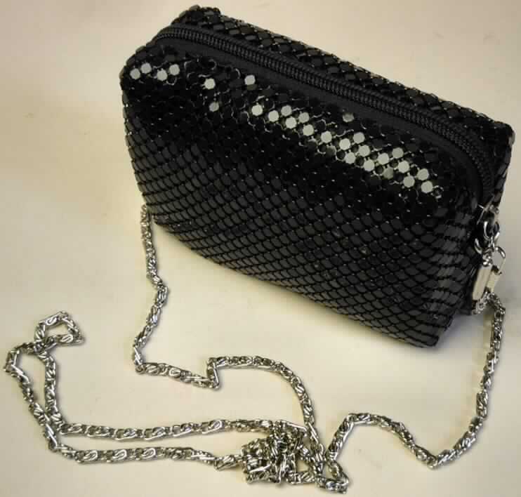 Handtasche, ähnlich einem Theatertäschchen, sog. Glitter Bag, Art.-Nr.: 6030187, verpackt in einer klarsichtigen Kunststofffolienbox in Herzform, innen mit buntbedruckter Pappeinlage, Abbildung siehe Anlage, 
- Handtaschenkörper aus zwei einfarbigen Spinnstofflagen mit einer Zwischenlage aus 
  Schaumstoff, 
- mit einer Außenseite aus verketteten, schwarzen Kunststoffplättchen, 
- mit den Abmessungen von ca. 12,5 (B) x 18,5(H) x 4,5 (T) cm, 
- mit einem Reißverschluss an der Oberseite,  
- mit einer Metallkette als Schultertragegurt, 
- innen ohne weitere Einteilung, gefüttert, 
- Handtasche, da aufgrund der Form, Größe und Aufmachung in erster Linie dazu geeignet,
  kleine persönliche Gegenstände aufzunehmen,
- verpackt in einer für derartige Waren handelsüblichen Verkaufsumschließung.

"Handtasche mit einem Taschenkorpus aus Spinnstoffen und einer Außenseite aus
 Kunststoffplättchen."