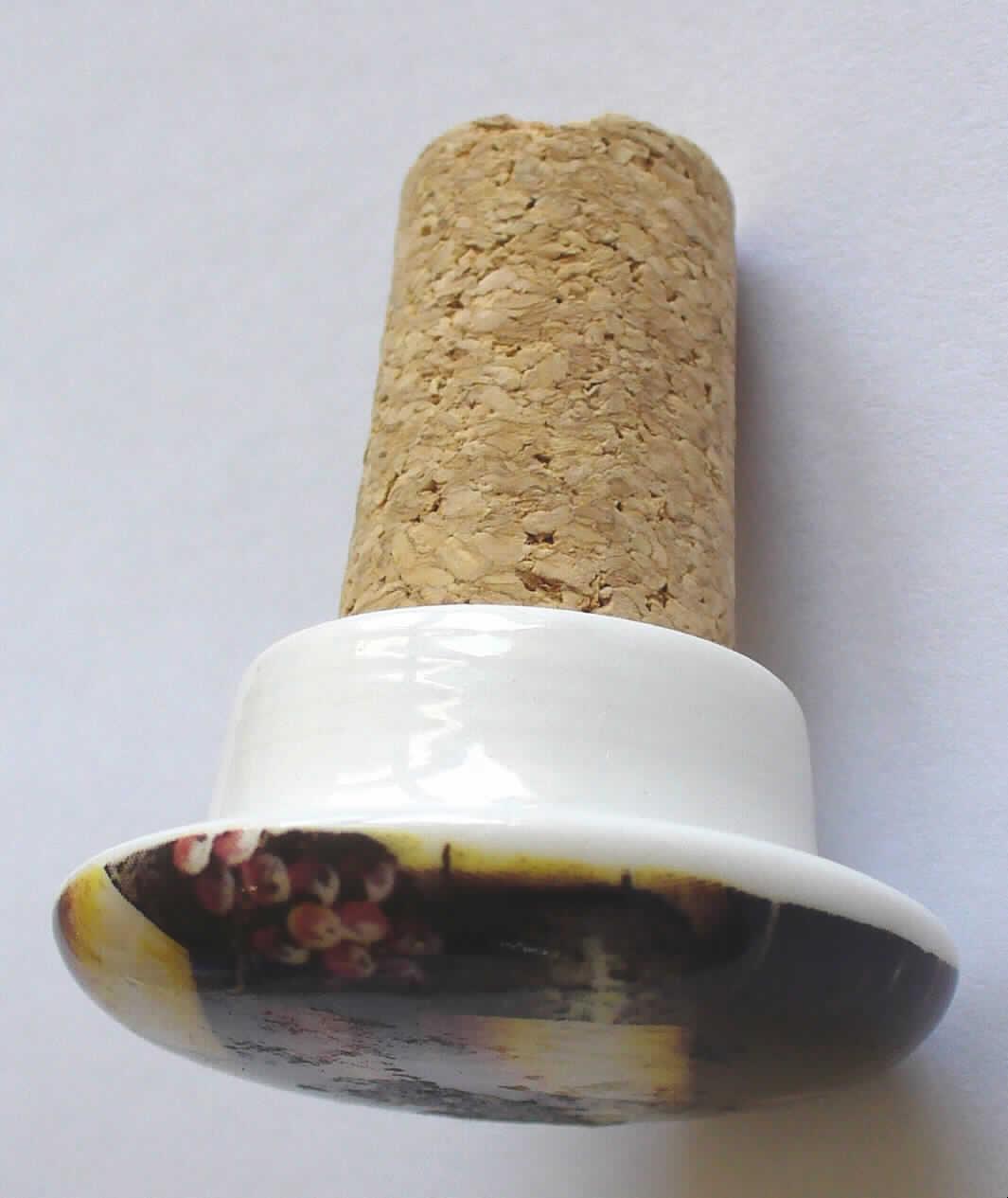 Flaschenverschluss
Die als "Weinflaschen-Verschluss" bezeichnete Ware besteht aus
- einem ca. 34 mm langen, konisch geformten Stopfen aus Presskork und
- einem ca. 19 mm hohen, pilzförmigen Griff aus Keramik (lt. Antrag aus Porzellan)
  mit einem maximalen Durchmesser von ca. 42 mm.
Der Stopfen ist durch Kleben mit dem Griff fest verbunden.
Der konische Presskorkstopfen gewährleistet die für die offensichtlich mehrfache Verwendung des Erzeugnisses maßgebliche Verschlussfunktion und ist daher als
charakterverleihend anzusehen.