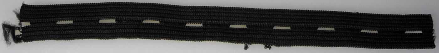 Gewirke, sog. Knopfloch Gummilitze, Art. Nr. 729943, Foto siehe Anlage,
- als Meterware; laut Antrag mit einer Länge von 1 m und einer Breite von 16 mm,
- aus augenscheinlich Polyester (synthetische Chemiefasern) und Gummi (Kautschukfäden), mit einem Anteil an 
  Kautschukfäden von augenscheinlich mehr als 5 GHT,
- ohne Flor- oder Schlingenoberfläche,
- mit regelmäßig eingearbeiteten, ca. 7 mm langen, schlitzförmigen Öffnungen (keine Konfektionierung i. S. d. 
  Anmerkung 7 zu ABS XI).

"Gewirke mit einer Breite von weniger als 30 cm und mit einem Anteil an Kautschukfäden von mehr als 5 GHT, 
 anderes als solche der Position 6001"