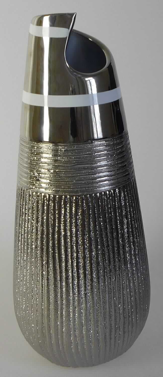 Keramischer Ziergegenstand, sog. Dekovase silverfarben, Artikel 38210-23, Foto siehe Anlage,
- silberfarbene, glasierte Vase,
- auf der Außenseite überwiegend mit geriffelter Struktur; am oberen Rand von unregelmäßiger Form,
- keramisches Erzeugnis; nach der Formgebung gebrannt; tonmineralhaltiges Material enthaltend,
- - nach dem Ergebnis der wissenschaftlichen Untersuchung aus anderer Keramik als Porzellan,
    Steinzeug, Steingut, feinen Erden oder gewöhnlichem Ton bestehend,
- in den Abmessungen: ca. 31 cm (Höhe) x 13 cm (max. Durchmesser),
- ohne Hinweise auf Handarbeit.

"Keramischer Ziergegenstand (Vase), aus anderer Keramik als Porzellan, gewöhnlicher Ton, Steinzeug,
 Steingut oder feinen Erden, nicht handgearbeitet"