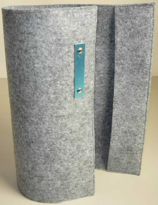 Buchhülle, sog. Notizbuchetui "Filz" A5, Art. 07004012-00000, Foto siehe Anlage,
- annähernd rechteckig; flachliegend in den Abmessungen von ca. 32,5 cm x 22 cm,
- laut Untersuchungsergebnis:
-- aus Nadelfilz aus Spinnstoffen, einseitig (Außenseite) dünn mit Kunststoff bestrichen, 
- an den Enden in der Länge von ca. 5,5 cm nach innen umgeschlagen und an den Längsseiten so 
  zusammengenäht, dass zwei Laschen zum Einschieben der Einbände von Büchern entstehen, 
- mit einem durch Nieten angebrachten Plättchen aus unedlem Metall (ca. 8 cm x 2,5 cm) verziert,
- durch Zusammennähen konfektioniert.

"Andere konfektionierte Ware (Notizbuchetui), aus Spinnstoffen, aus Filz"