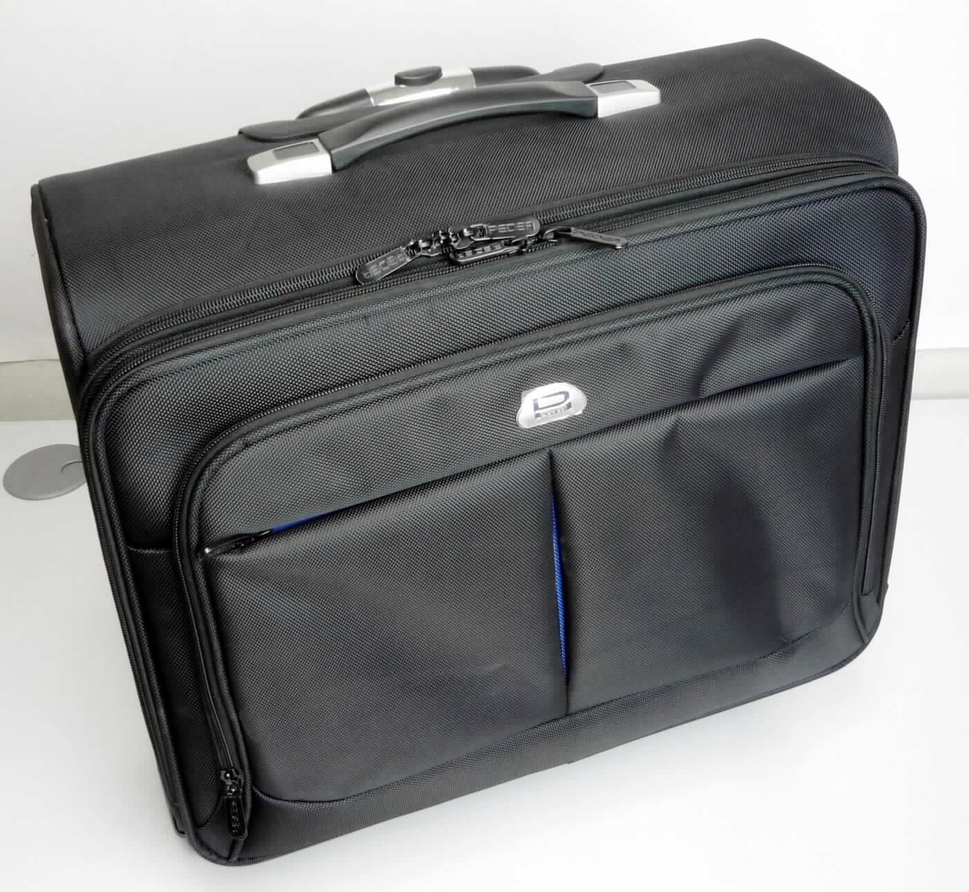 Aktenkofferähnliches Behältnis, sog. Trolley / Rollkoffer, Foto siehe Anlage,
- mit einer Außenseite aus Spinnstoffen, 
- - mit einem kleinen Emblem aus unedlem Metall sowie einem kleinen Kunststofffach mit einem herausziehbaren
    Adresskärtchen aus Papier,
- mit einem ausziehbaren Griff zum Ziehen des Koffers auf vier Rollen (Trolleyfunktion),
- mit einem Handtragegriff, 
- mit zwei großen, unterteilten Vorfächern mit jeweils einem dreiseitig umlaufenden Reißverschluss,
- - vorderes Vorfach:
- - - außen mit einem eingesetzten Einsteckfach mit Reißverschluss,
- - - innen auf einer Seite mit einem Einsteckfach mit Klettverschlusslasche, auf der anderen Seite mit einem
      Einsteckfach mit Überschlagklappe mit Klettverschluss, vier Einsteckfächern im Kartenformat, drei Stiftlaschen
      und einem Schlüsselring,
- - hinteres Vorfach:
- - - mit zwei Trennstegen,
- Hauptfach:
- - mit einem großen Einsteckfach mit Klettverschlusslasche (sog. Notebookfach), einem herausnehmbaren,
    gepolsterten, großen Einsteckfach und Gurten mit Schnappverschlüssen,
- mit den Abmessungen von ca. 46 cm (Breite) x 40 cm (Höhe) x 24 cm (Tiefe), 
- ohne Hinweise auf Handarbeit. 

"Aktenkofferähnliches Behältnis, mit einer Außenseite aus Spinnstoffen, nicht handgearbeitet"