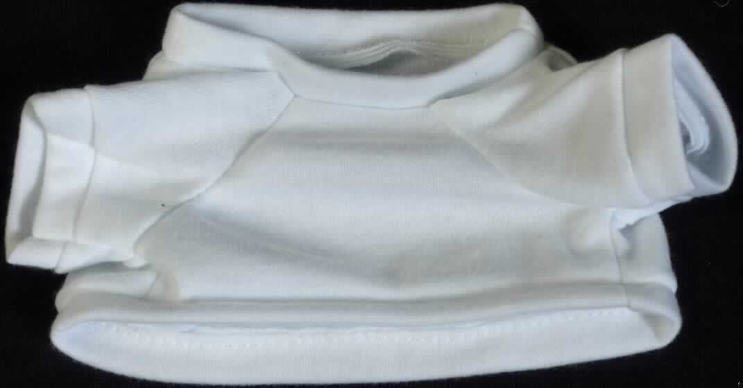 Es handelt sich um ein ca. 9 x 16,5 cm (HxB; Breite mit Ärmeln) großes, weißes T-Shirt aus Spinnstoff mit einem runden Halsausschnitt und kurzen Ärmeln. Der Kragenbereich, die Ärmelenden und der gerade, untere Rand des Shirts sind mit einem Bund ausgestattet.

Das T-Shirt ist aufgrund der Gestaltung erkennbar hauptsächlich als Zubehör für Puppen bestimmt. Eine mögliche Verwendung als Zubehör für Plüschtiere steht der Einreihung nicht entgegen. 

Die Ware dient der spielerischen Unterhaltung von Kindern mit Puppen.

Das Erzeugnis ist als "Zubehör für Puppen, nur Nachbildungen von Menschen darstellend" einzureihen.