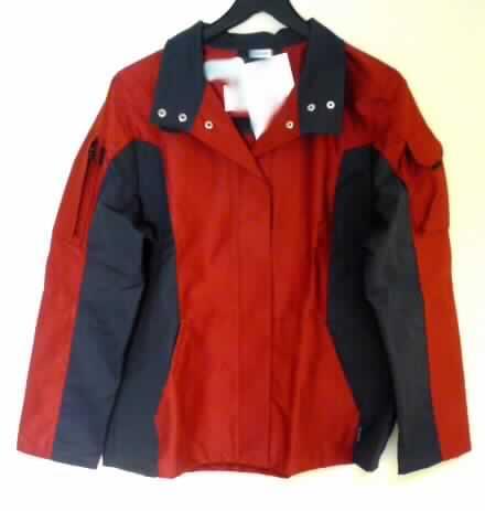 Jacke (Arbeitsjacke) für Frauen, sog. Jacke, Größe 38, siehe Foto,
- aus verschiedenen, 0,5 mm dicken, einfarbigen, festen, teilweise köperbindigen Geweben
  aus laut Antrag 65% Polyester (synthetische Chemiefasern) und 35% Baumwolle; unter
  den Armen mit Einsätzen aus einfarbigen Gewirken; ungefüttert,
- mit einem Reverskragen, der auch zu einem Stehkragen geschlossen werden kann,
- vorn mit einer durchgehenden Öffnung mit Druckknopfverschluss von rechts über links 
  (Frauenkleidung),
- über die Taille reichend (Rückenlänge 67 cm), 
- mit langen Ärmeln,
- mit zwei aufgesetzten Taschen unterhalb der Taille (somit u.a. keine Hemdbluse der
  Position 6206) und Taschen im Bereich der Oberarme,
- am unteren, nicht verengenden Rand gesäumt (somit kein Blouson der Position 6202),
- aufgrund des strapazierfähigen Materials und des zweckbestimmten, einfachen Schnitts
  erkennbar dazu bestimmt, ausschließlich oder hauptsächlich zum Schutz der Person und/
  oder der Kleidung getragen zu werden (somit Arbeits- und Berufskleidung).
