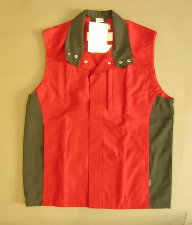 Weste für Männer, sog. Herrenweste, Größe 50, siehe Foto,
- aus verschiedenen, 0,5 mm dicken, festen, teilweise köperbindigen Geweben aus laut
  Antrag 65% Polyester (synthetische Chemiefasern) und 35% Baumwolle,  
- über den Schritt reichend (Rückenlänge: 77 cm), 
- mit einem Umlegekragen, der zu einem Stehkragen geschlossen werden kann,
- vorn mit einer durchgehenden Öffnung mit Druckknopfverschluss von links über rechts
  (Männerkleidung), 
- ärmellos,
- mit einer Brusttasche und zwei Taschen unterhalb der Taille,
- am unteren Rand gesäumt,
- aufgrund des strapazierfähigen Materials und des zweckbestimmten, einfachen Schnitts
  erkennbar dazu bestimmt, ausschließlich oder hauptsächlich zum Schutz der Person und/
  oder der Kleidung getragen zu werden (somit Arbeits- und Berufskleidung).