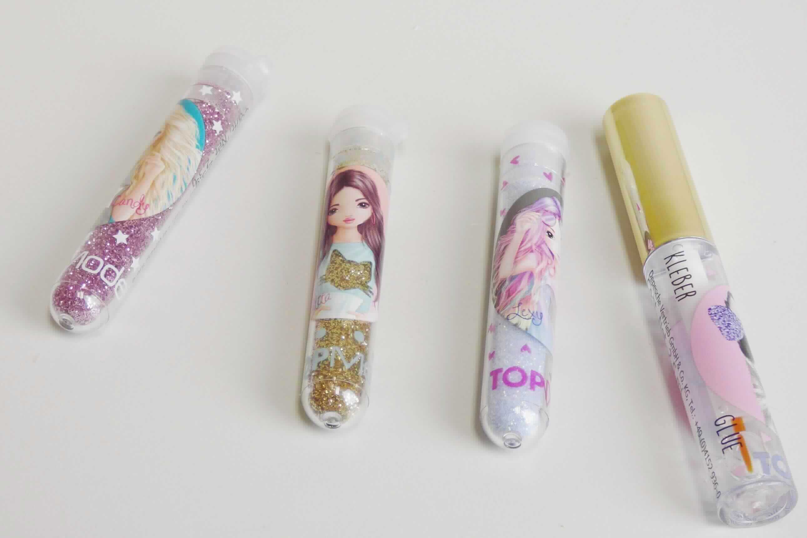 Nach den Angaben liegt ein Glitter-Kleber-Set vor. Aus den Untersuchungsergebnissen geht hervor, dass es sich um eine Warenzusammenstellung bestehend aus einer kleinen Klebstoffflasche mit Pinsel und drei Kunststoffröhrchen die goldfarbiges, pinkes und durchsichtiges Glitterpulver enthalten, handelt. Die Glitterpartikel sind in Hinblick auf den Umfang und die Verwendung charakterverleihend. Die farbigen, glitzernden Pulver bestehen aus Polyethylenterephthalat wobei weitere Kunststoffe enthalten sind. Es wird unterstellt, dass der Anteil an PET weniger als 95 GHT beträgt. Die Glitterpartikel sind sehr fein und fast pulverförmig, und es ist keine geometrische Form mit dem Auge erkennbar.

Die Ware ist als anderer Polyester in Primärform in die Codenummer 3907 9980 90 0 des Zolltarifs einzureihen.