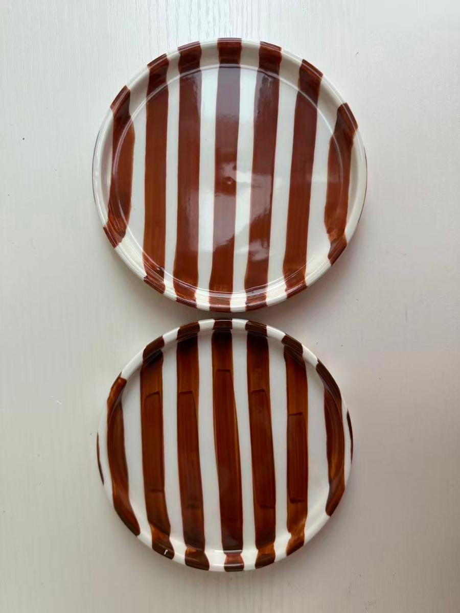 Geschirr aus Porzellan, sog. Unterteller, Foto siehe Anlage,
- weiß-braun gestreifter, glasierter, runder Teller,
- mit einem gerade hochgezogenen Rand,
- in den Abmessungen: ca. 12﻿,﻿5 cm (Durchmesser) x 2 cm (Höhe),
- keramisches Erzeugnis, nach der Formgebung gebrannt, tonmineralhaltiges Material enthaltend,
- laut Antrag aus Porzellan.

"Geschirr (Teller), aus Porzellan"