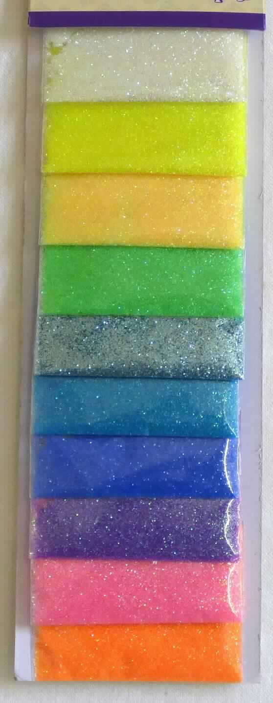 Angaben des Antragstellers: 
Glitzer Set in 10 Farben sortiert

Feststellungen an einem Warenmuster:
Es wurden farbige, annähernd sechseckige Glitter-Partikel vorgelegt, welche farblich sortiert in zehn kleinen Kunststofftüten abgefüllt und für den Einzelverkauf aufgemacht sind. Die Partikel bestehen aus Polyethylenterephthalat mit einer Viskositätszahl von weniger als 78 ml/g.

Befund:
Es liegt Polyethylenterephthalat in Primärformen im Sinne der Unterposition (KN) 3907 6900 vor.
