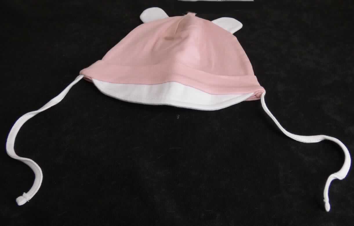 Kopfbedeckung, sog. Babykappe mit Schirm, Abbildung siehe Anlage, 
- durch Zusammennähen von Stücken aus Spinnstofferzeugnissen (Gewirke aus laut Antrag 100 % Baumwolle) 
  annähernd der Kopfform entsprechend hergestellt, 
- mit einem mit Vliesstoff verstärkten, 3 cm breiten Schirm, 
- mit einem umgeschlagenen und festgenähten Rand, 
- oben mit zwei angenähten, stilisierten Ohren versehen,
- mit zwei Schnürbändern zum Binden unter dem Kinn ausgestattet.

"Kopfbedeckung, aus mehreren Stücken von Spinnstofferzeugnissen hergestellt, Mütze mit Schirm"