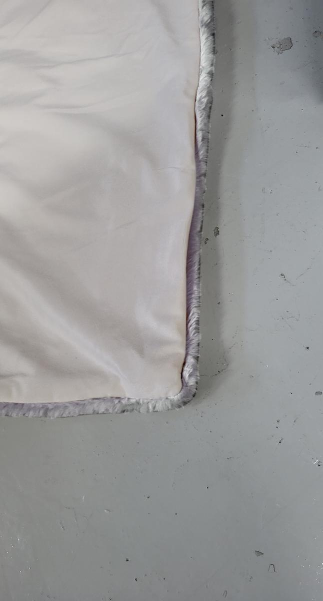 Decke, sog. Kunstfelldecke AMIRA, Foto siehe Anlage,
- in einer zusammengebundenen, mit einem bedruckten Pappetikett versehenen Schleife aus
  Spinnstoffen verpackt,
- rechteckig, in den Abmessungen von laut Antrag 130 cm x 180 cm,
- zweilagig gearbeitet; mit einer Lage aus einfarbigen, hochflorigen Plüschgewirken und einer Lage
  aus einfarbigen Samtgewirken; beide aus laut  Antrag 100 % Polyester (synthetischen Chemie-
  fasern), damit kein künstliches Pelzwerk der Position 4304,
- ohne elektrische Heizvorrichtung,
- an den Rändern zusammengenäht (somit konfektioniert),
- ohne Polsterung oder Füllung, somit keine Ware der Position 9404.

"Decke, aus Spinnstoffen, ohne elektrische Heizvorrichtung, aus synthetischen Chemiefasern, aus
 Gewirken"