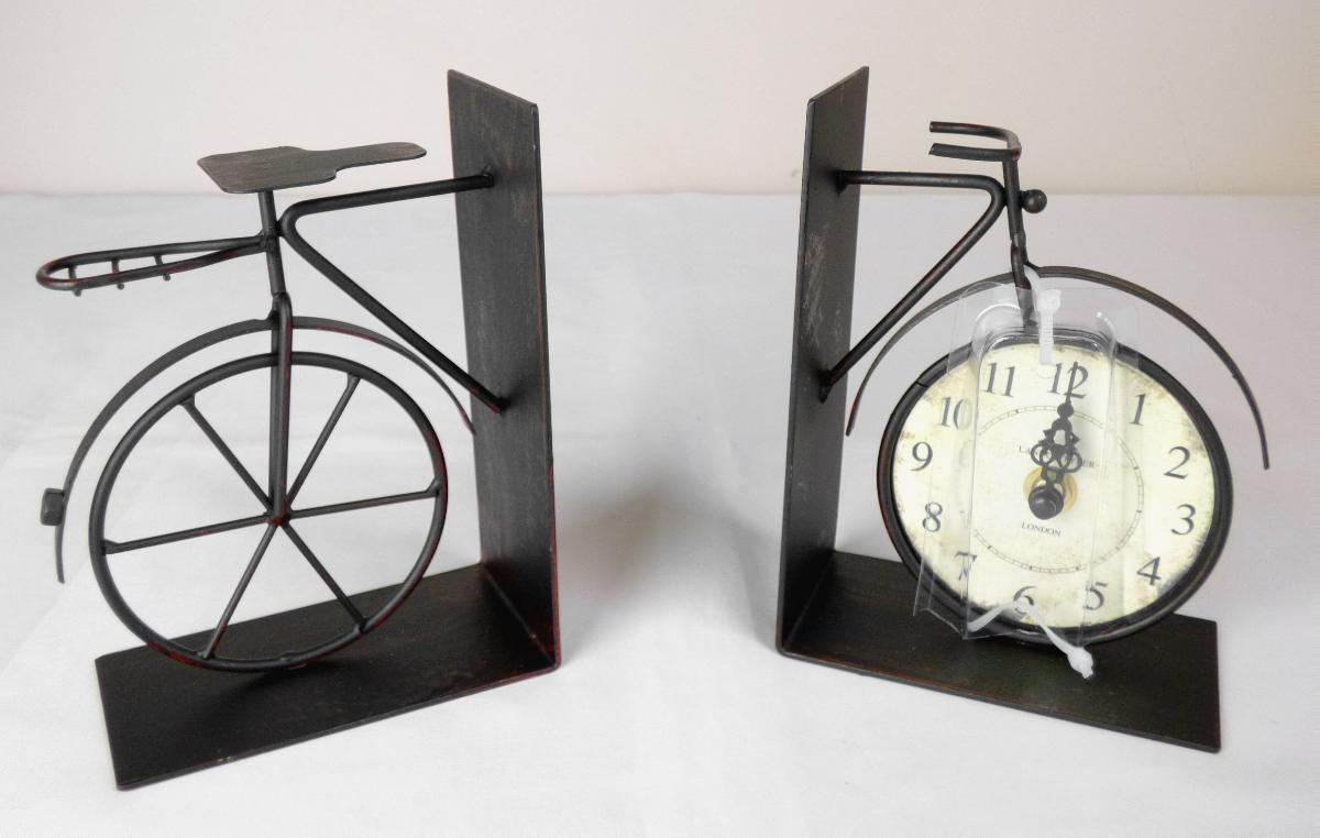 Es handelt sich um zweiteilige Buchstützen (Artikelnr. 2729800), jeweils bestehend aus einem etwa 9 cm x 11 cm x 15 cm großem, L-förmig abgewinkelten Blech aus unedlem Metall, das an einer Seite zu einem Zierelement in Form von einem halben Fahrrad ausgearbeitet ist. Das Vorderrad wird dabei durch eine batteriebetriebene, analoge Uhr in nostalgischem Design gebildet.
-Antragstellerangaben-

Aufgrund der Bedeutung für die Verwendung bestimmen die zweiteiligen Buchstützen den Charakter der aus verschiedenen Bestandteilen zusammengesetzten Waren.

Eine Einreihung der Waren als „Ziergegenstände“ in die Position 8306 kommt aufgrund des Gebrauchswertes der Erzeugnisse nicht in Betracht.

Die Buchstützen sind als "ähnliche Ausstattungsgegenstände für Büros, aus unedlen Metallen" in die Codenummer 8304 0000 00 0 des Zolltarifs einzureihen.

Abbildung siehe Anlage.
