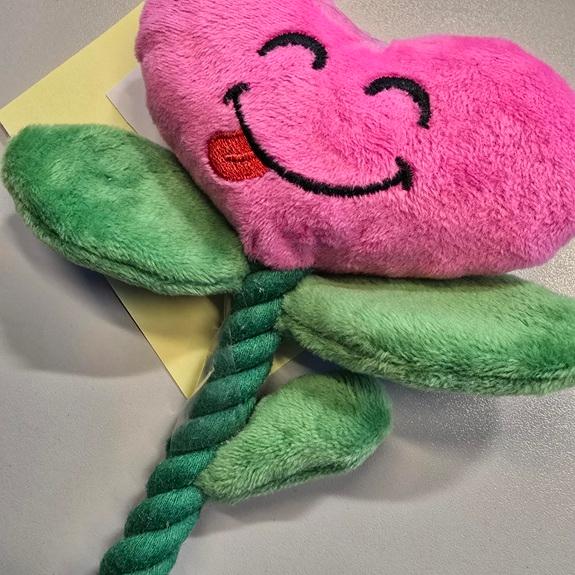 Tierspielzeug, Foto siehe Anlage,
- laut Antrag an einem Hangtag mit dem Hinweis auf Hundespielzeug befestigt,
- in Form einer stilisierten "Herz-Blume" mit den Abmessungen (L x B x T) von laut Antrag 25 cm x
  10 cm x 1 cm,
- mit einer "Blüte" in Form eines stilisierten Herzens aus einfarbigen Samtgewirken (Abmessungen
  ca. 12 cm x 8 cm) mit Wattierungsstoff sowie einer Knisterfolie aus Kunststoff gefüllt und mit 
  einem aufgestickten "Gesicht" verziert, 
- mit einem eingenähten "Stängel" aus einem ca. 1﻿,﻿3 cm dicken und 15 cm langen dreilitzigen Seil,
  das am unteren Ende geknotet und ausgefranst ist; mit drei eingearbeiteten "Blättern" aus einem 
  zweilagigen Textillaminat der Position 6001 mit einer charakterverleihenden Außenlage (Schau-
  seite) aus einfarbigen Plüschgewirken und einer Innenlage aus Zellkunststoff,
- alle Flächenerzeugnisse bestehen aus laut Antrag Polyester (synthetische Chemiefasern),
- durch Zusammenfügen konfektioniert,
- aufgrund der Aufmachung erkennbar für Tiere bestimmt, somit keine Ware der Position 9503,
- insbesondere im Hinblick auf den Umfang bestimmen die Gewirke gegenüber dem Seil den
  wesentlichen Charakter der Ware.

"Andere konfektionierte Ware (Tierspielzeug), aus Spinnstoffen, aus Gewirken"