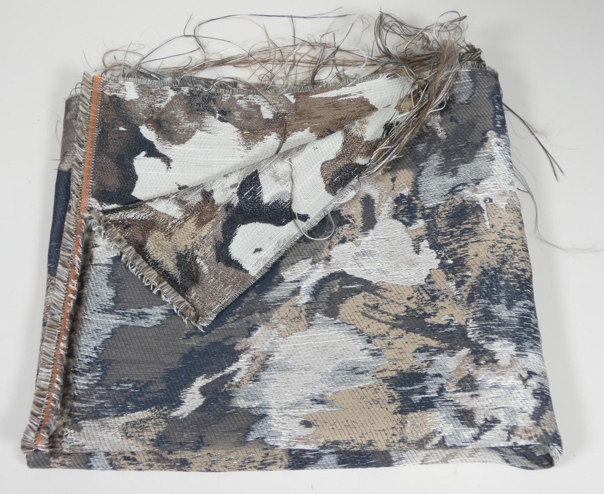 Jacquardgewebe, Foto siehe Anlage,
- als Meterware, mit einer Breite von mehr als 30 cm,
- laut Untersuchungsergebnis:
-- aus ungezwirnten, nicht hochfesten Garnen,
--- mit Kettgarnen aus texturierten, synthetischen Filamenten (laut Antrag Polyester),
--- mit dünnen Schussgarnen aus texturierten, synthetischen Filamenten (laut Antrag Polyester),
--- mit dicken Schussgarnen aus künstlichen Spinnfasern (Viskose),
-- mit einem Anteil:
--- an synthetischen Filamenten von ca. 90 GHT,
--- an künstlichen Spinnfasern von ca. 10 GHT,
-- buntgewebt.

"Gewebe aus Garnen aus synthetischen Filamenten, anderes als in den Unterpositionen (HS)
 5407 10 bis 5407 44 genannte, mit einem Anteil an texturierten Polyester-Filamenten von mehr als
 85 GHT, buntgewebt"