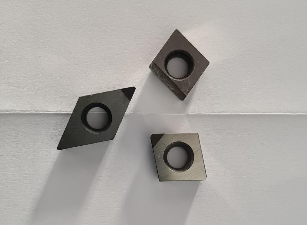 Keramische Waren zu technischen Zwecken, sog. Wendeschneidplatten,
- harte, ungefasste, quadratische oder rautenförmige, mittig gelochte Schneidplatten in verschiedenen
  Ausführungen,
- aus verschiedenen Stoffen zusammengesetzte Waren, bestehend aus:
- - einem Träger aus Vollhartmetall,
- - jeweils mit einer oder mehreren aufgebrachten Schneidecken,
- - - aus anderen keramischen Stoffen als Porzellan:
- - - - kubisches Bornitrid (CBN) mit einem keramischen Bindemittel,
- - - - nach vorheriger Formgebung keramisch gebrannt,
- - - mit einer Mohsschen Härte von 9 oder mehr,
- zur Verwendung als Schneidkörper in Werkzeugmaschinen für die Metallbearbeitung,
- die keramischen Schneidecken verleihen den Waren insbesondere aufgrund ihrer Bedeutung
  in Bezug auf die Verwendung den wesentlichen Charakter,
- keine Waren des Kapitels 82, da die Schneidecken als arbeitende Teile nicht aus Stoffen bestehen,
  die gemäß Anmerkung 1 zu Kapitel 82 zugelassen sind (insbesondere kein Metallcarbid oder Cermet
  als arbeitendes Teil).

"Keramische Waren zu technischen Zwecken, andere als aus Porzellan, mit einer Mohsschen Härte
von 9 der mehr"